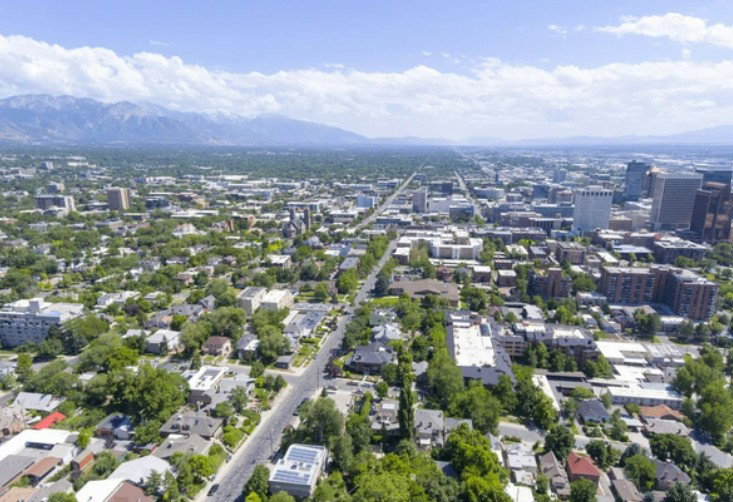 Expansive aerial perspective showcasing a metropolitan area with a backdrop of distant mountains