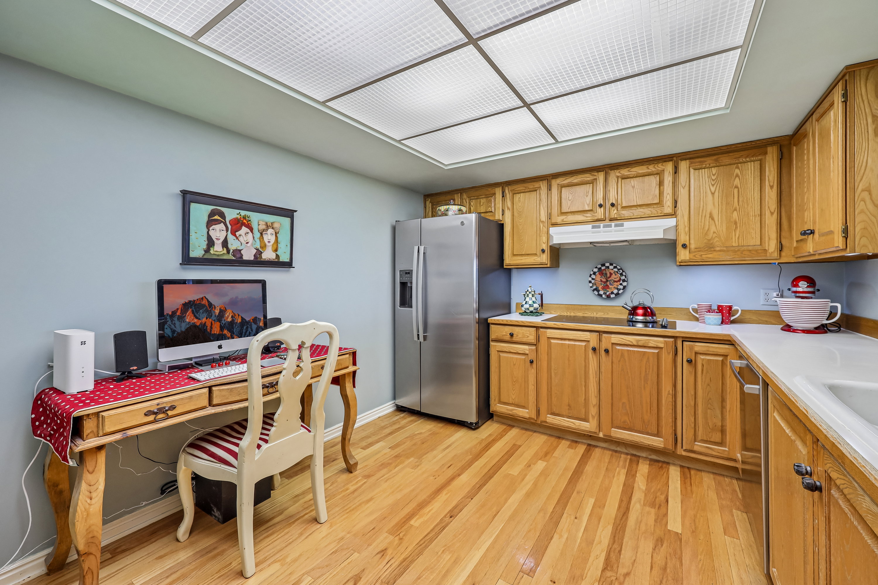 Kitchen featuring wood-finish flooring, light wood cabinetry, white countertops, and a full suite of stainless steel appliances