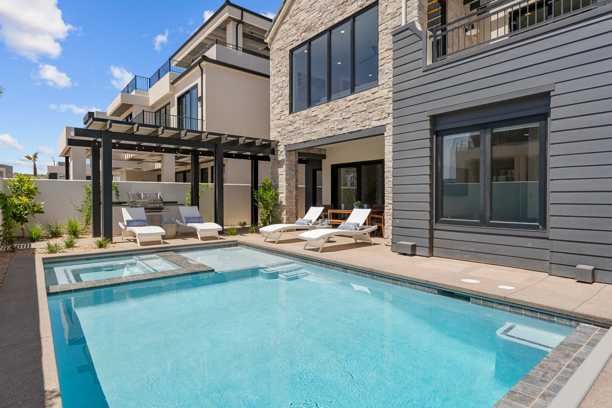 Outdoor swimming pool with integrated spa and adjacent patio