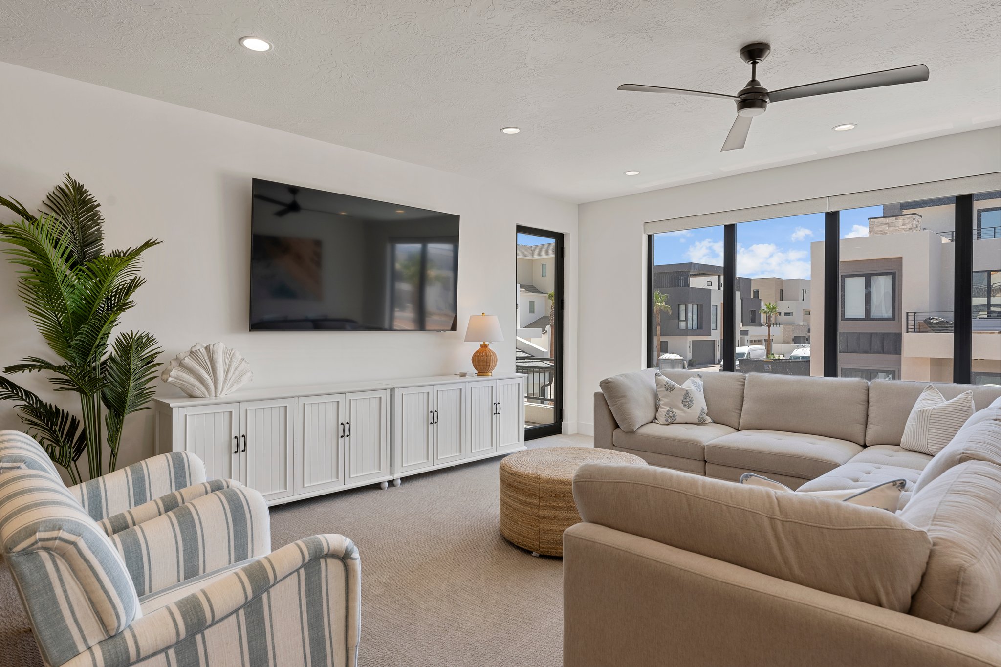 Spacious living area featuring large windows, recessed lighting, a ceiling fan, and a built-in media console with cabinet storage