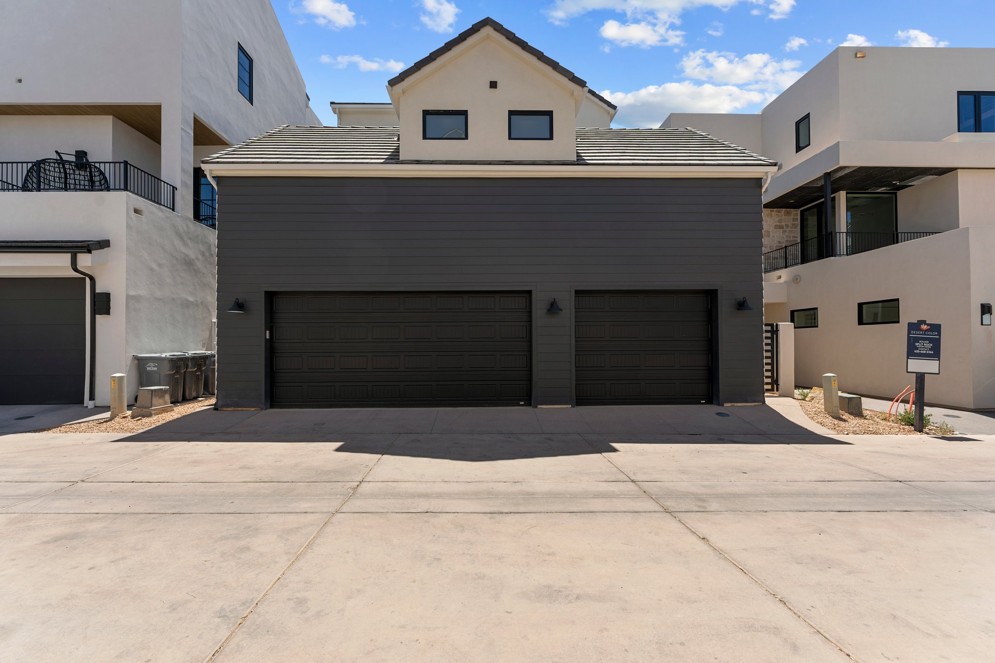 Modern exterior featuring dark gray siding and a light-colored stucco finish
