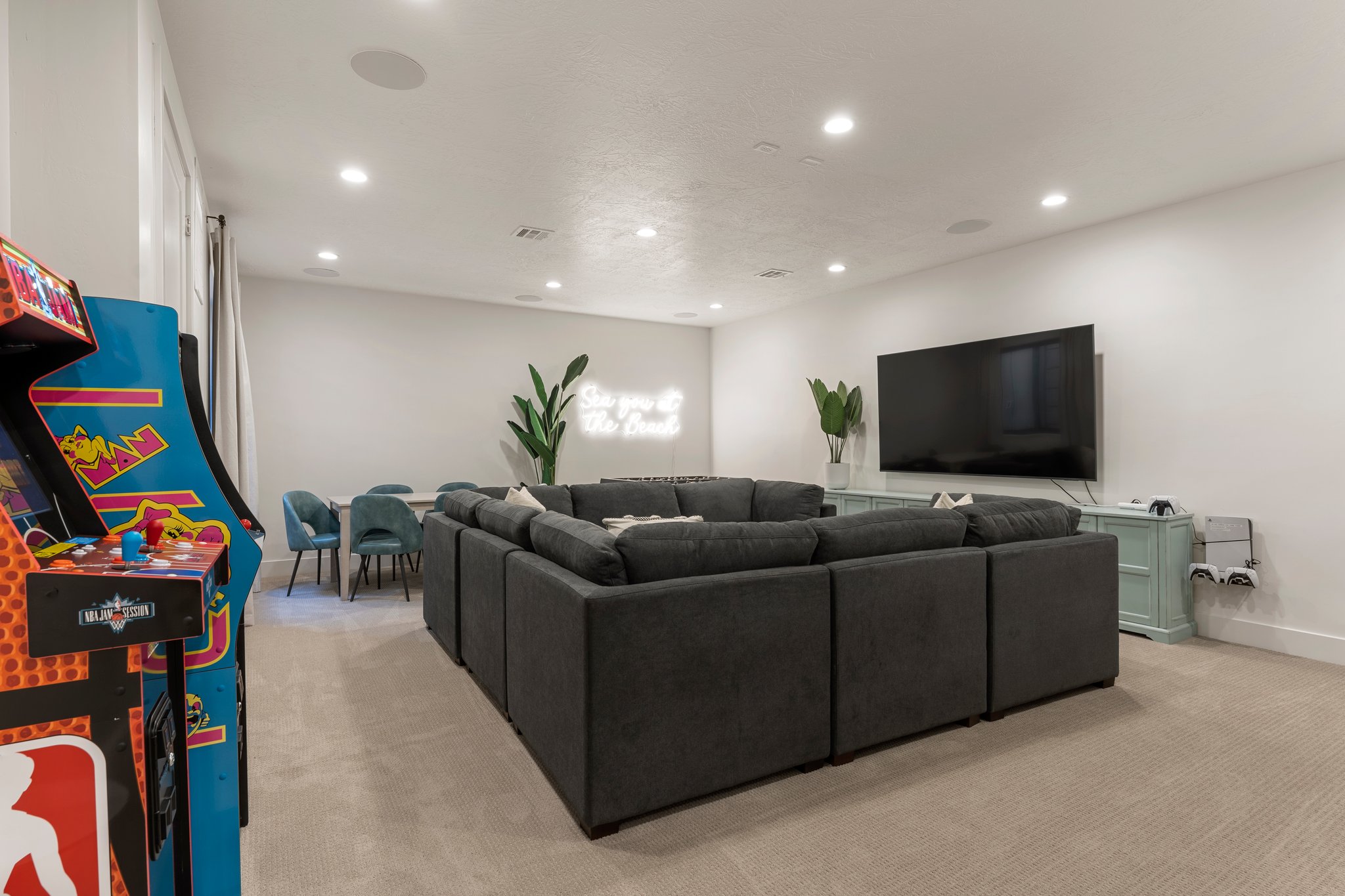 Spacious room featuring plush carpeting, recessed lighting, and a large wall-mounted screen
