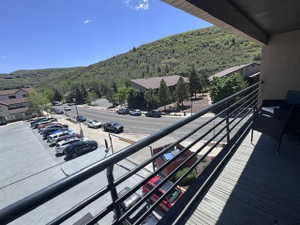 Balcony with wood-finish decking and a black metal railing