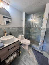 Bathroom featuring blue-toned stone-look flooring and wall tiles