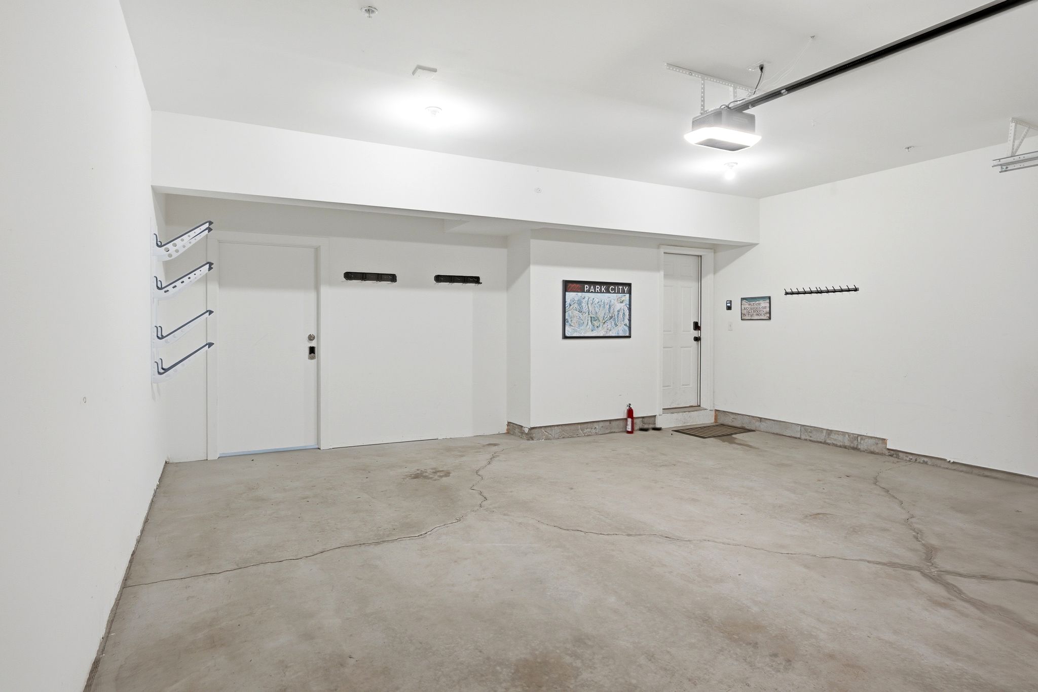 Spacious garage featuring a concrete floor, two entry doors, and built-in wall shelving