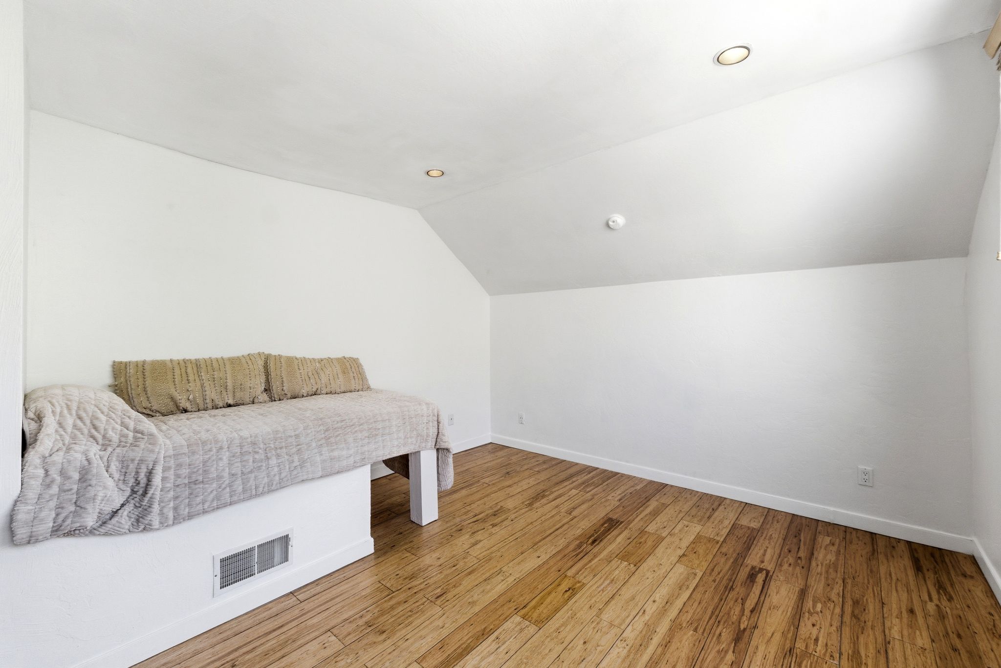 Room featuring wood-finish flooring, recessed lighting, and a built-in platform with a vent