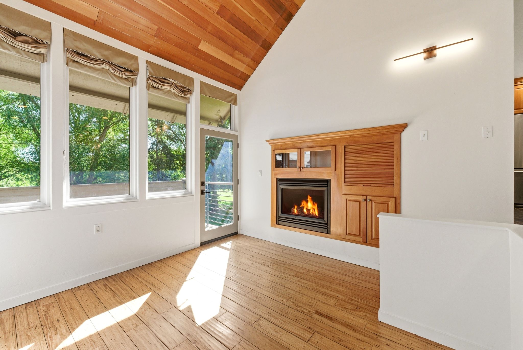 Vaulted wood-paneled ceiling accentuating a built-in fireplace with wood cabinetry