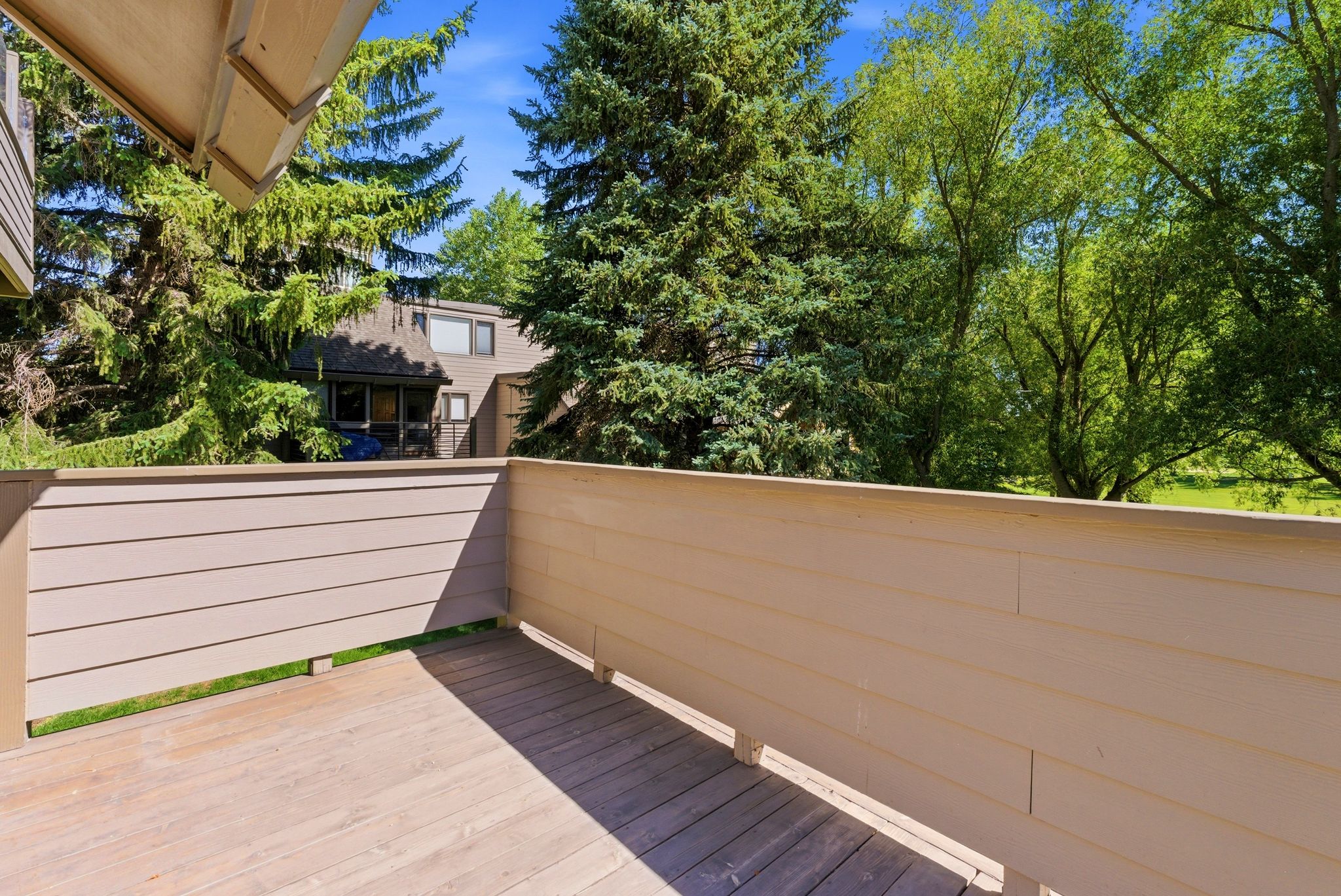 Outdoor deck featuring wood-finish flooring and light-toned horizontal railing