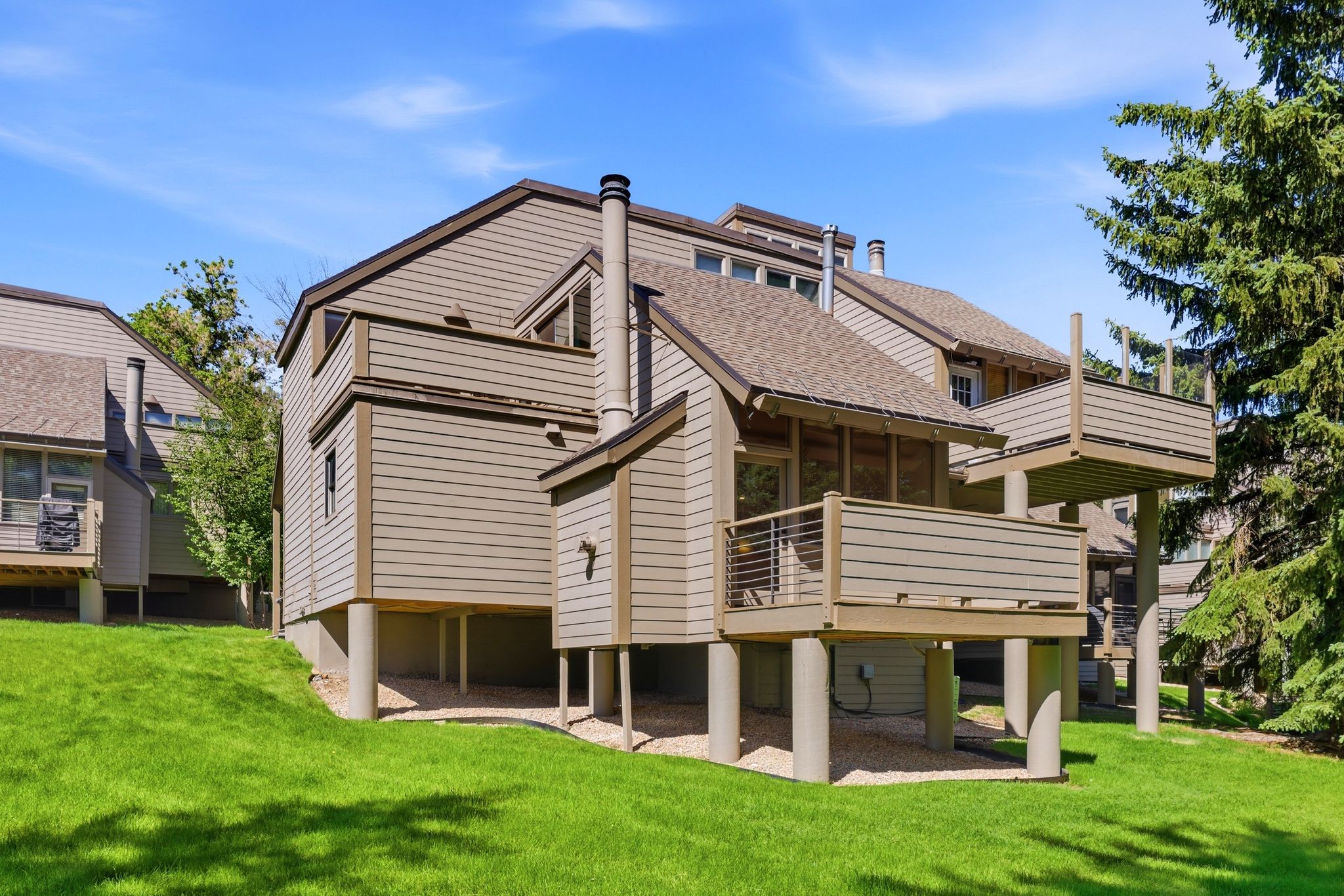 Multi-level property exterior with neutral siding and a pitched roof