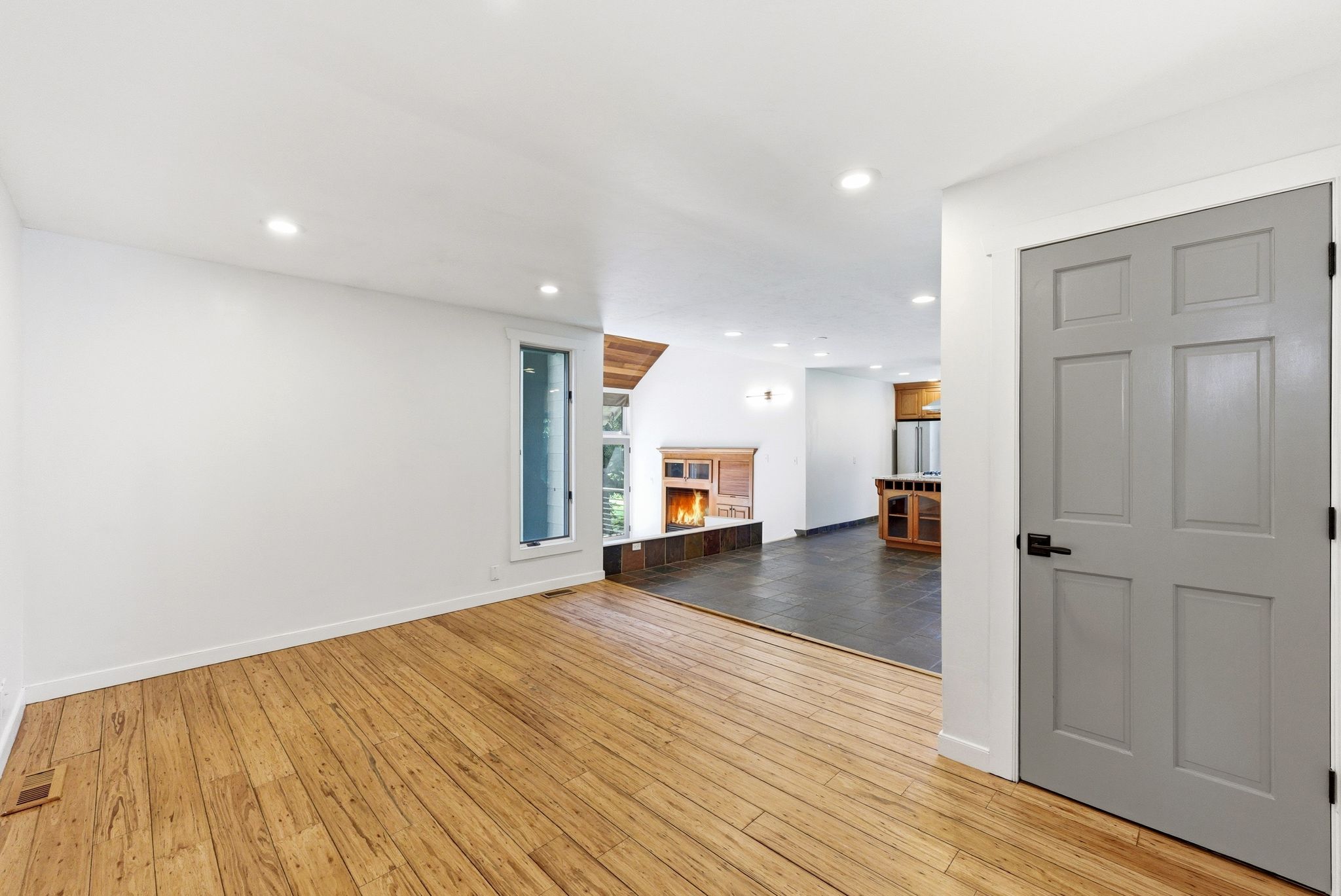 Bright room with wood-finish flooring, recessed lighting, and a vertical window