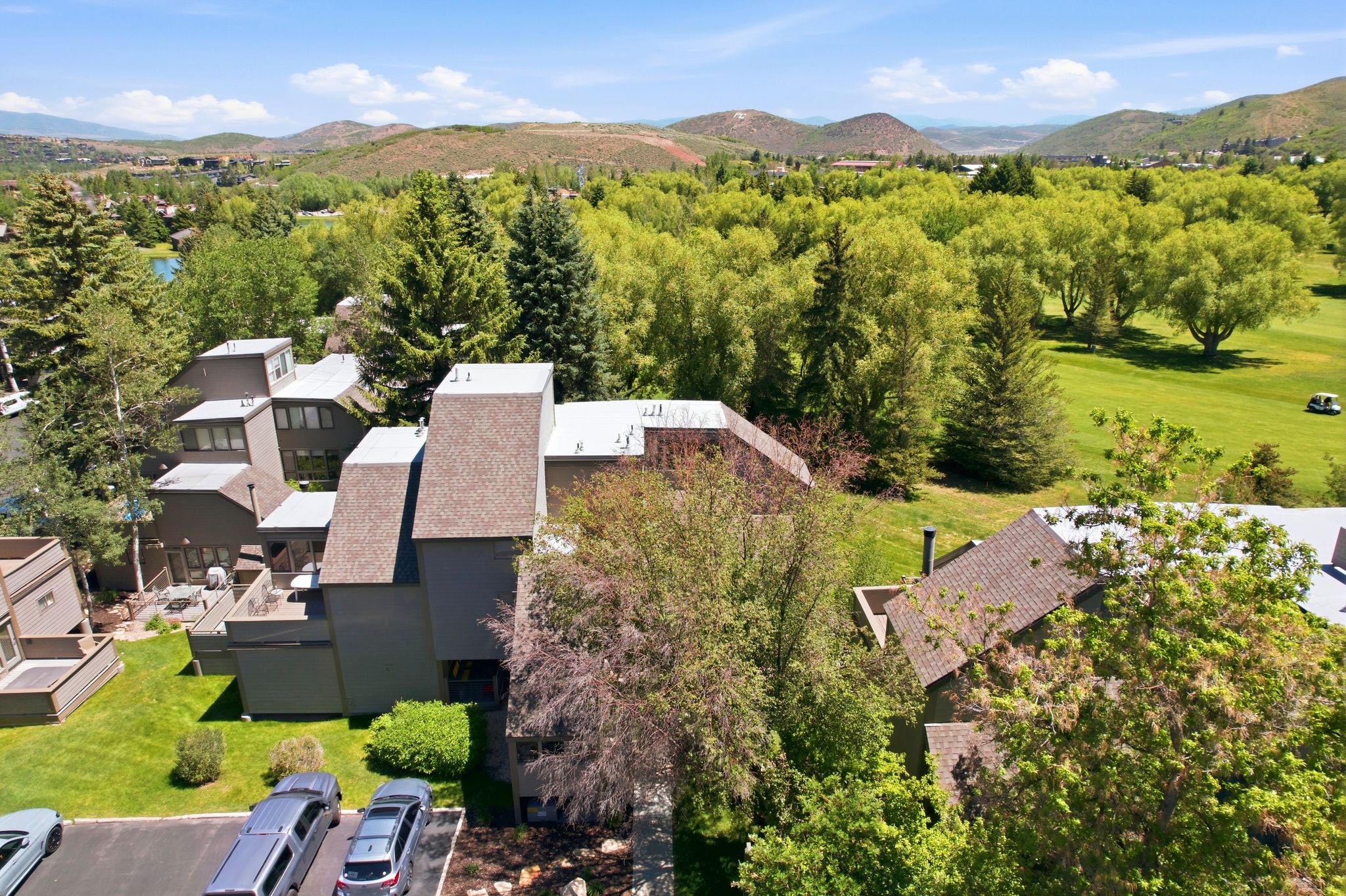 Contemporary multi-level building with shingled roofing and multiple balconies