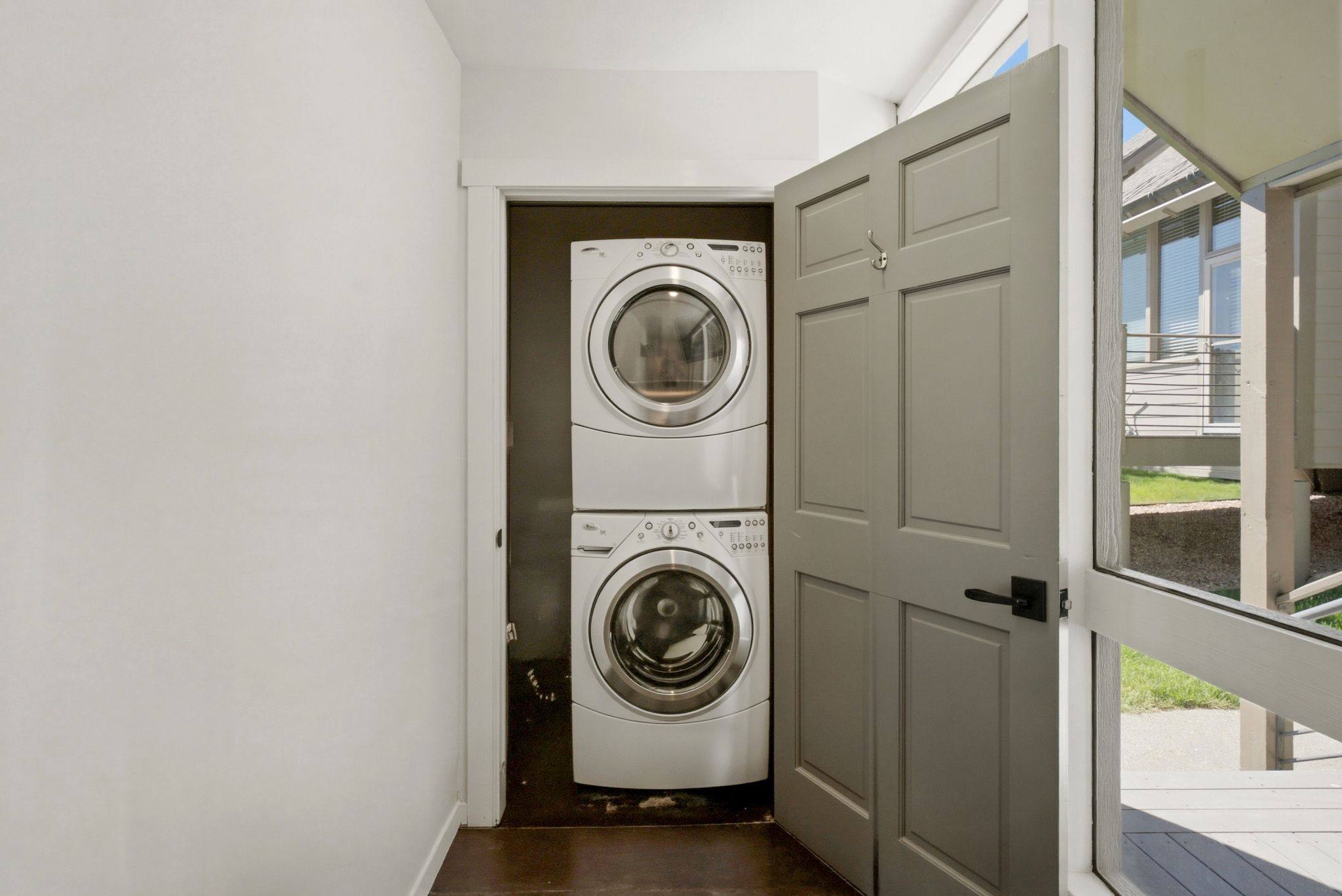 Dedicated laundry closet featuring a stacked washer and dryer