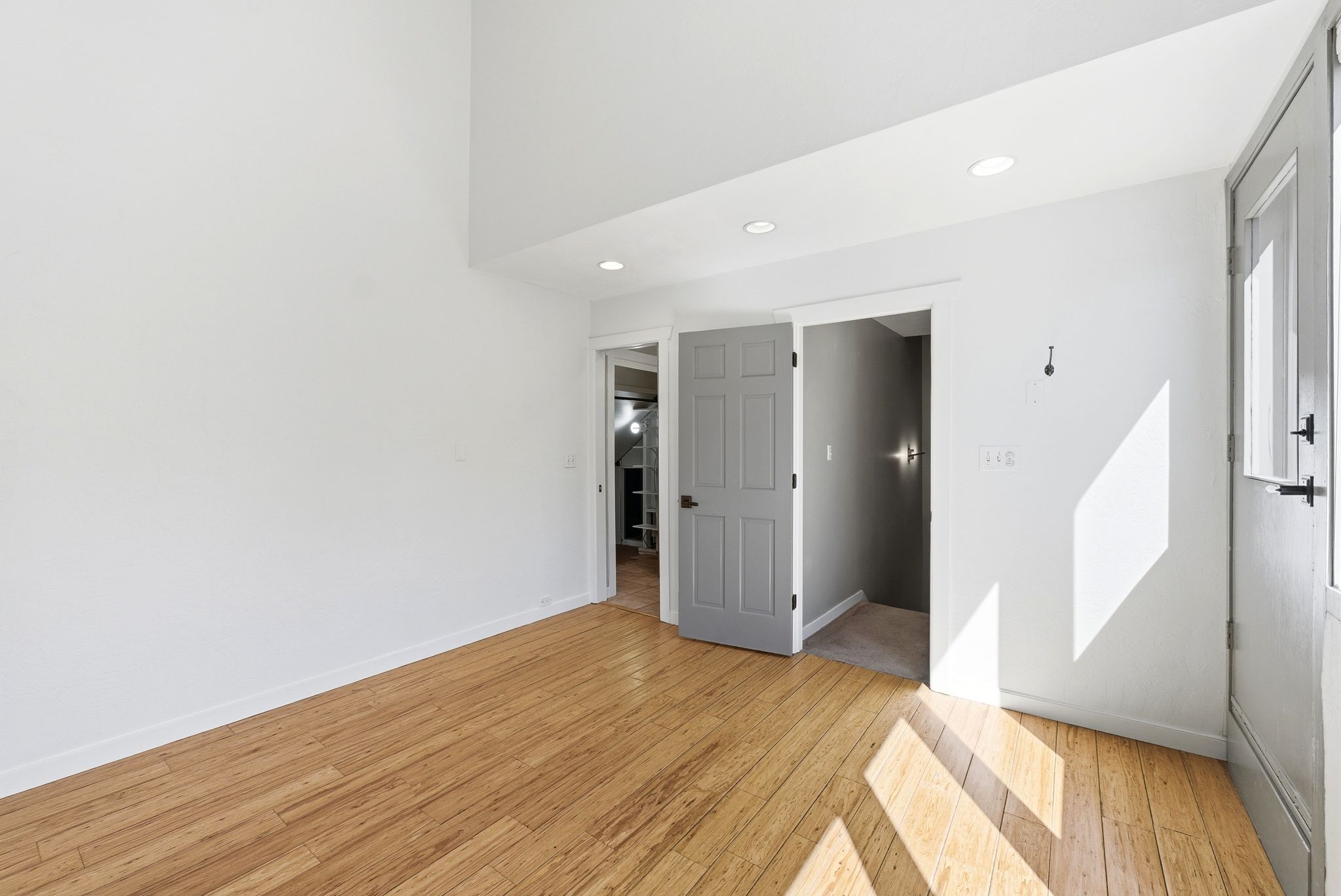 Bright interior space featuring wood-finish flooring, white walls, and recessed ceiling lighting