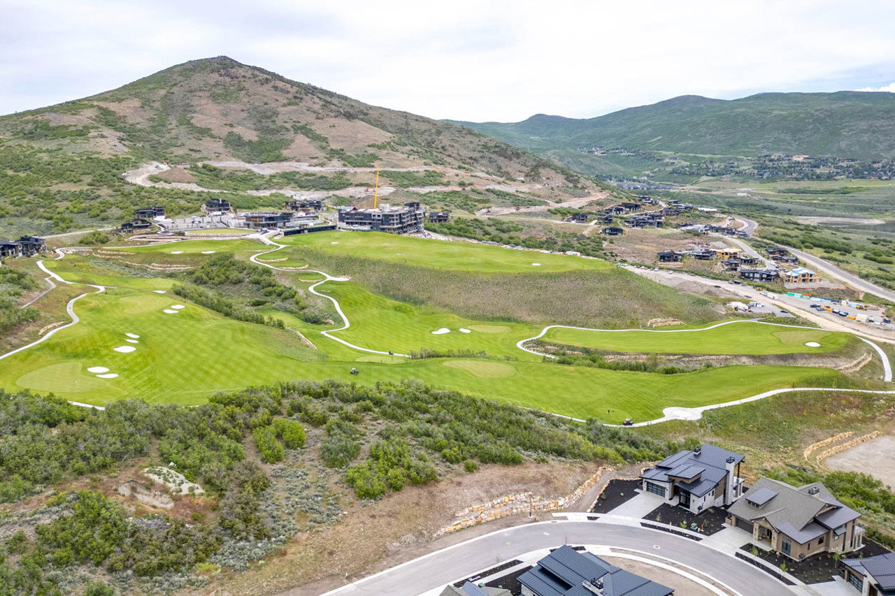 Aerial perspective showcasing golf course greens and scattered residential properties