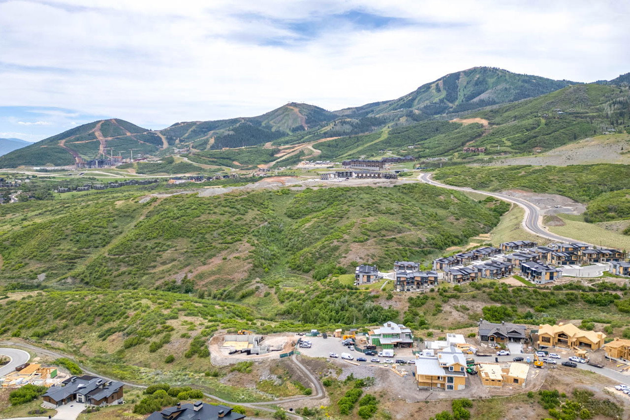 Expansive mountain landscape with diverse terrain, featuring multiple development sites and established residential clusters