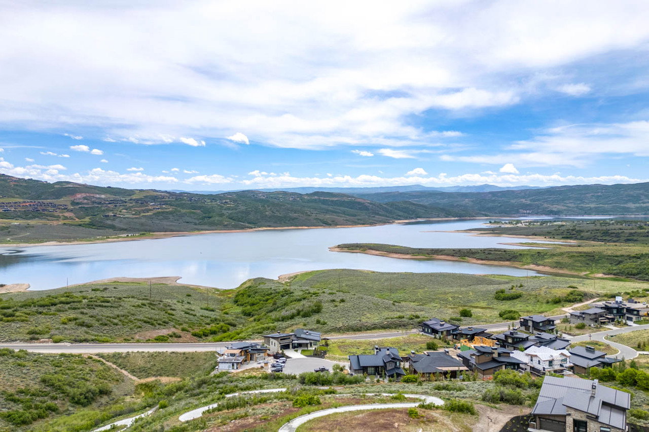 Expansive lake with surrounding green hills and distant mountains