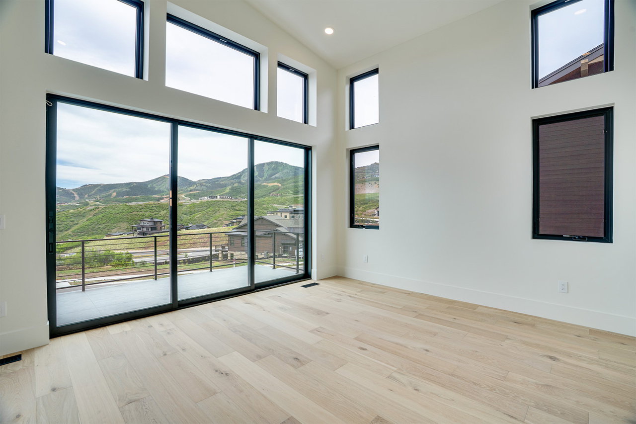 Expansive sliding glass doors open to a balcony with a metal railing
