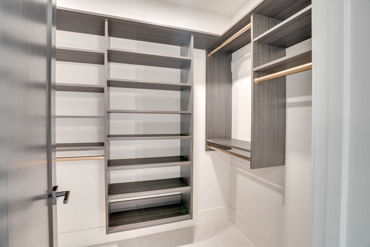 Custom closet system featuring dark wood-finish shelving and hanging rods