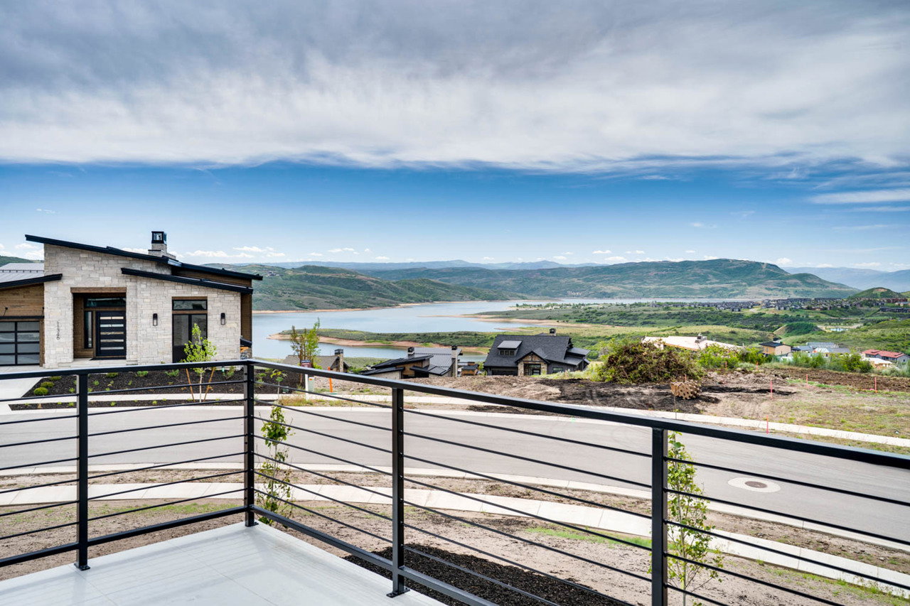 Modern exterior featuring stacked stone accents, a sloped roofline, and an expansive garage door