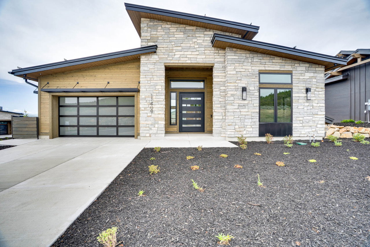 Contemporary exterior featuring stacked stone and horizontal wood-finish siding