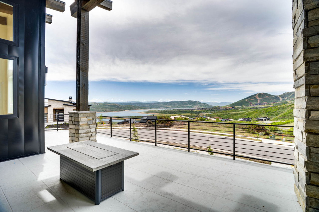 Expansive outdoor patio featuring a concrete surface and black metal railings