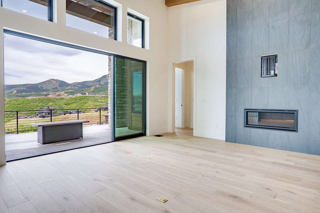 Great room featuring wide plank wood-finish flooring and a tiled fireplace surround with an integrated linear firebox