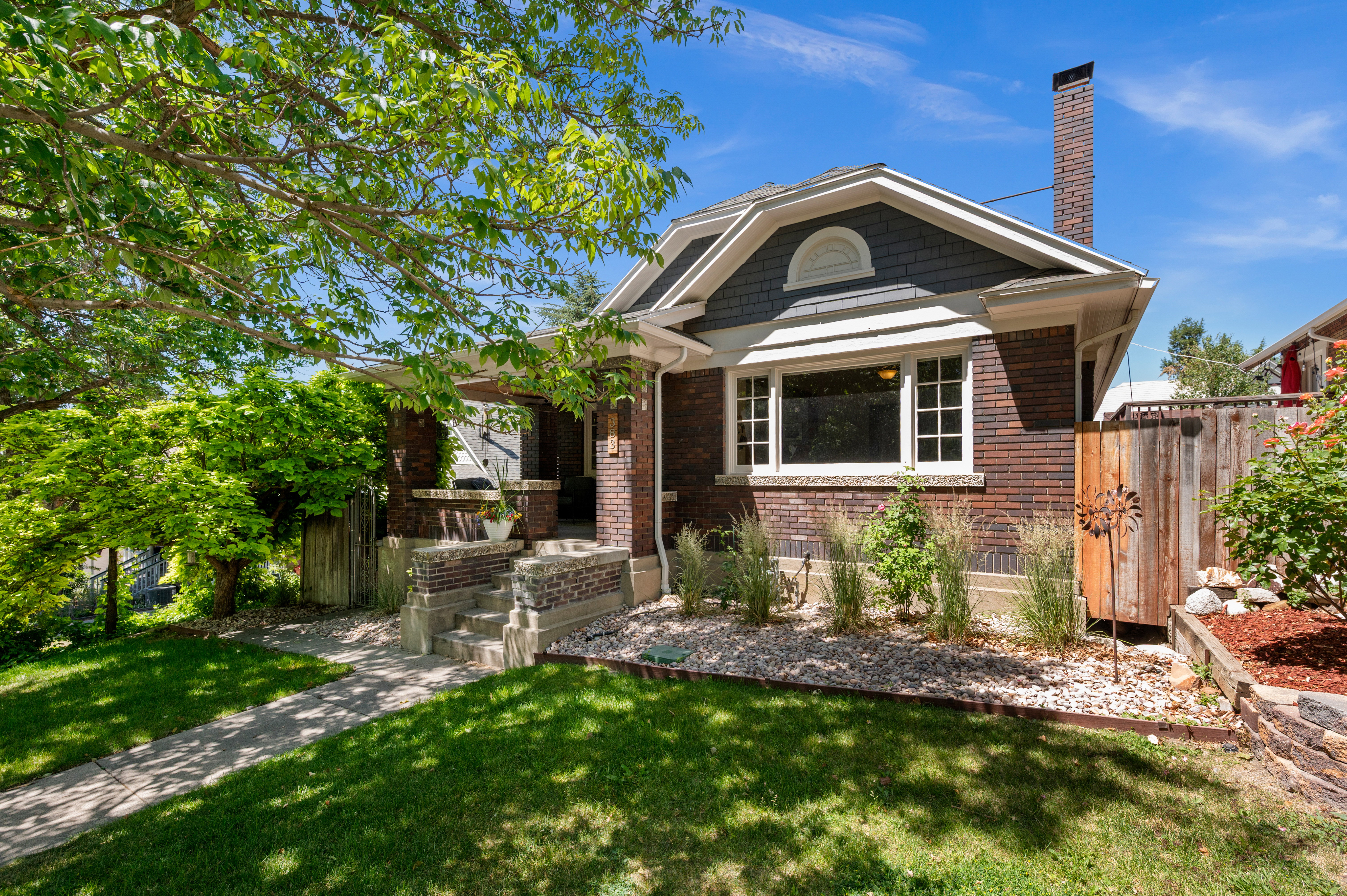 Brick exterior with white trim, featuring a prominent front window with gridded panes