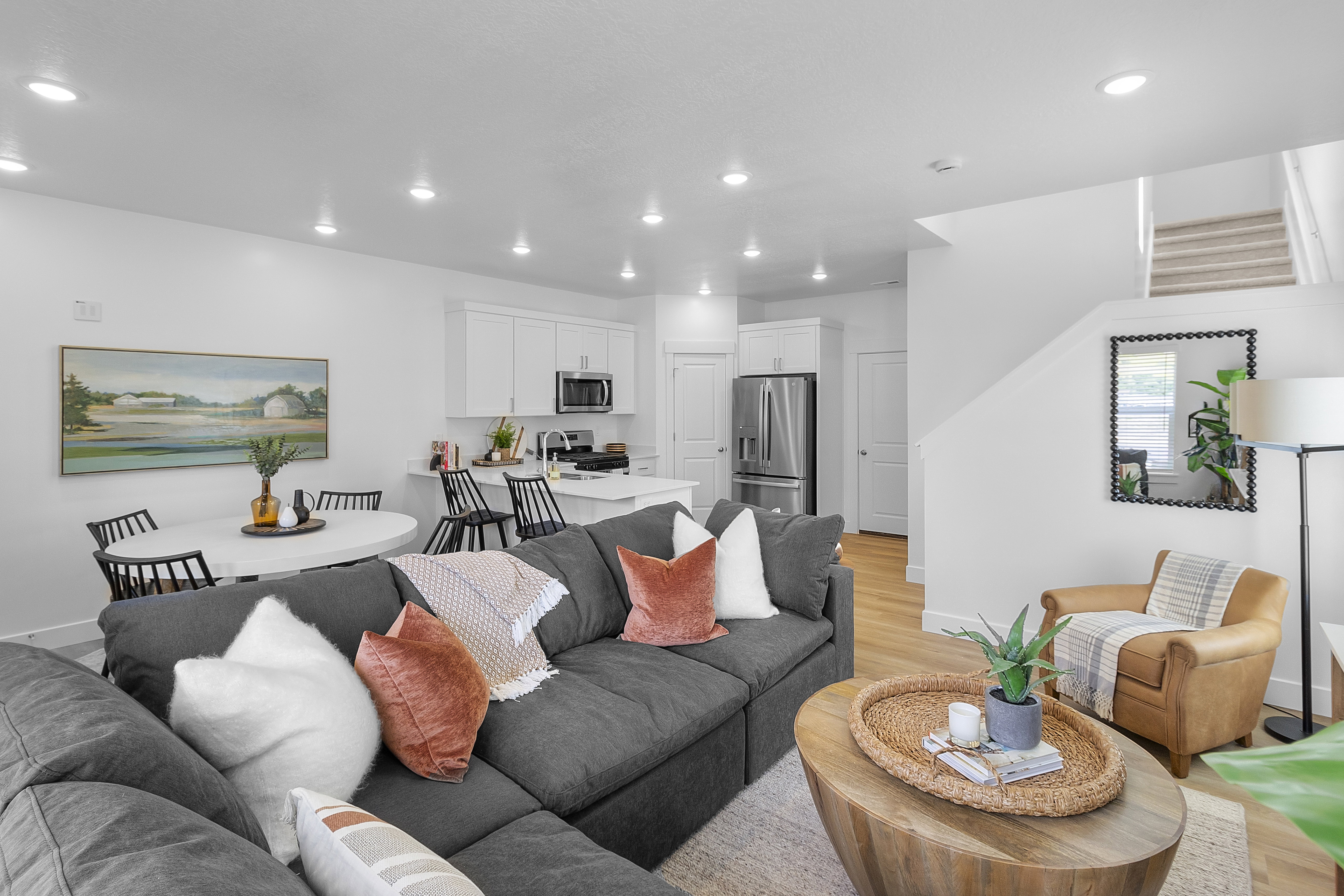 Open-concept living space featuring wood-finish flooring, recessed lighting, and a white color palette