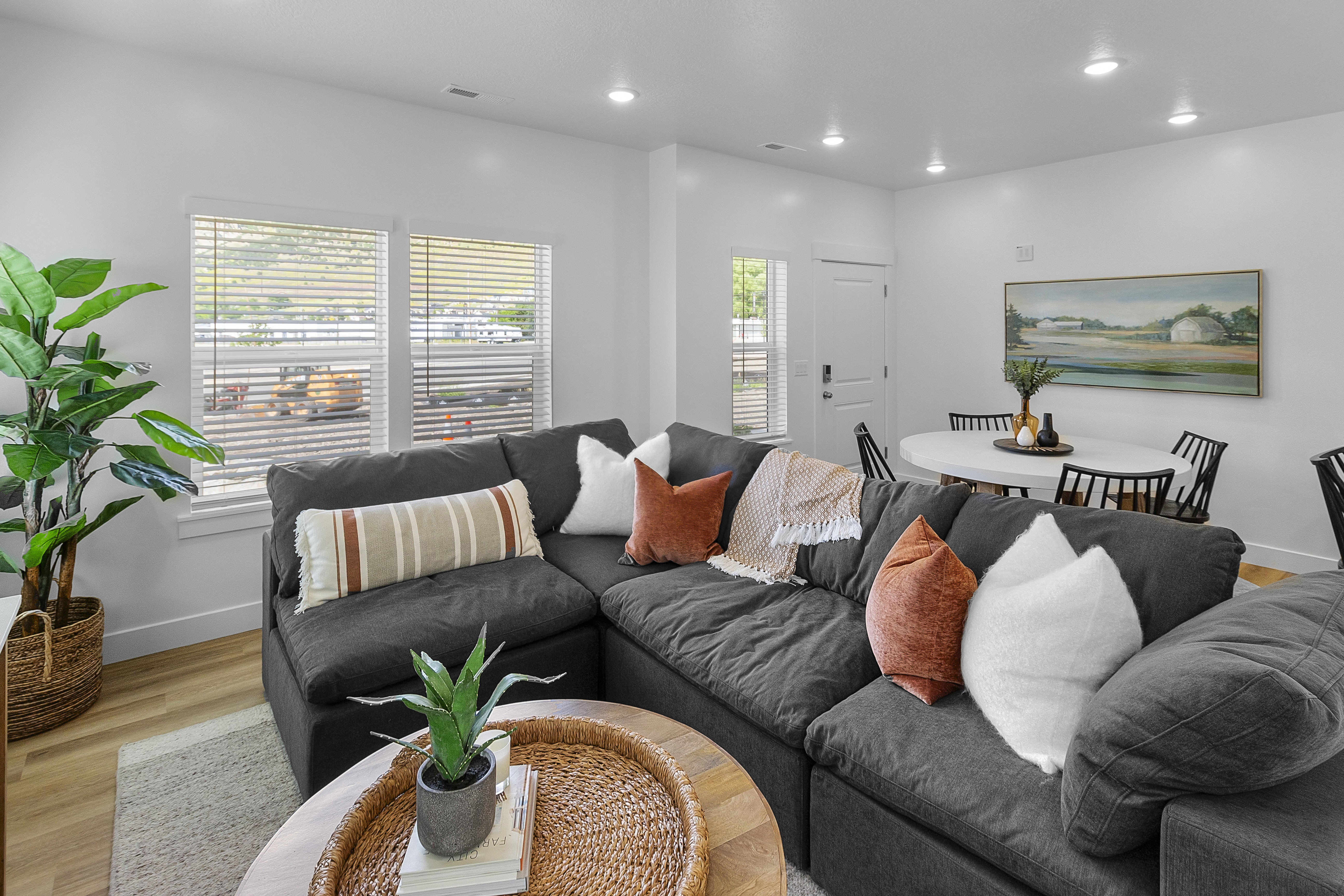Open-concept living area with light wood-finish flooring, recessed lighting, and white walls