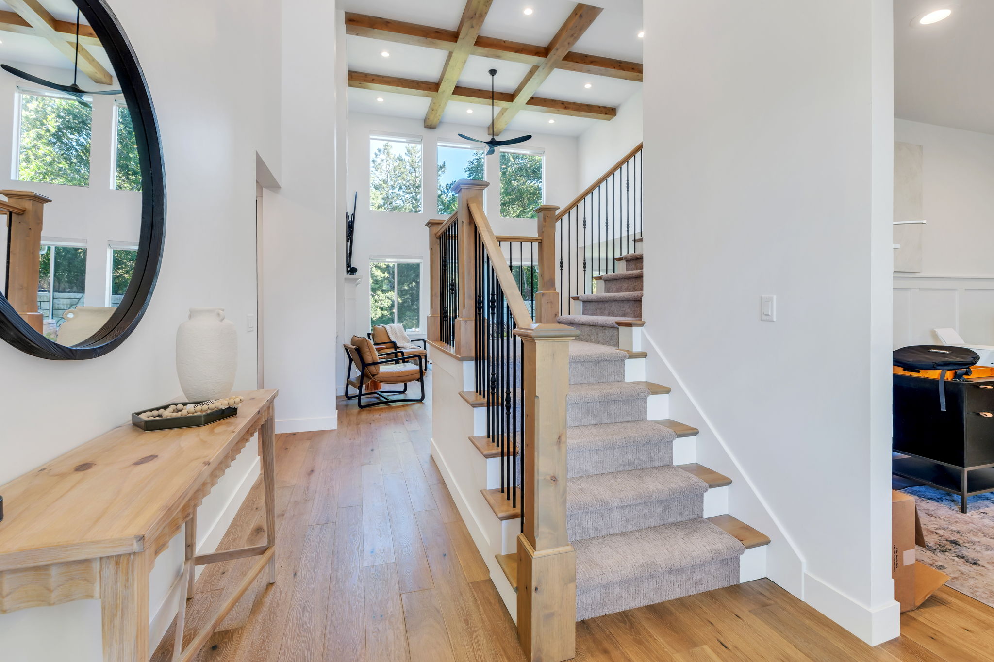 Grand entryway featuring a carpeted staircase with wood newel posts and iron balusters