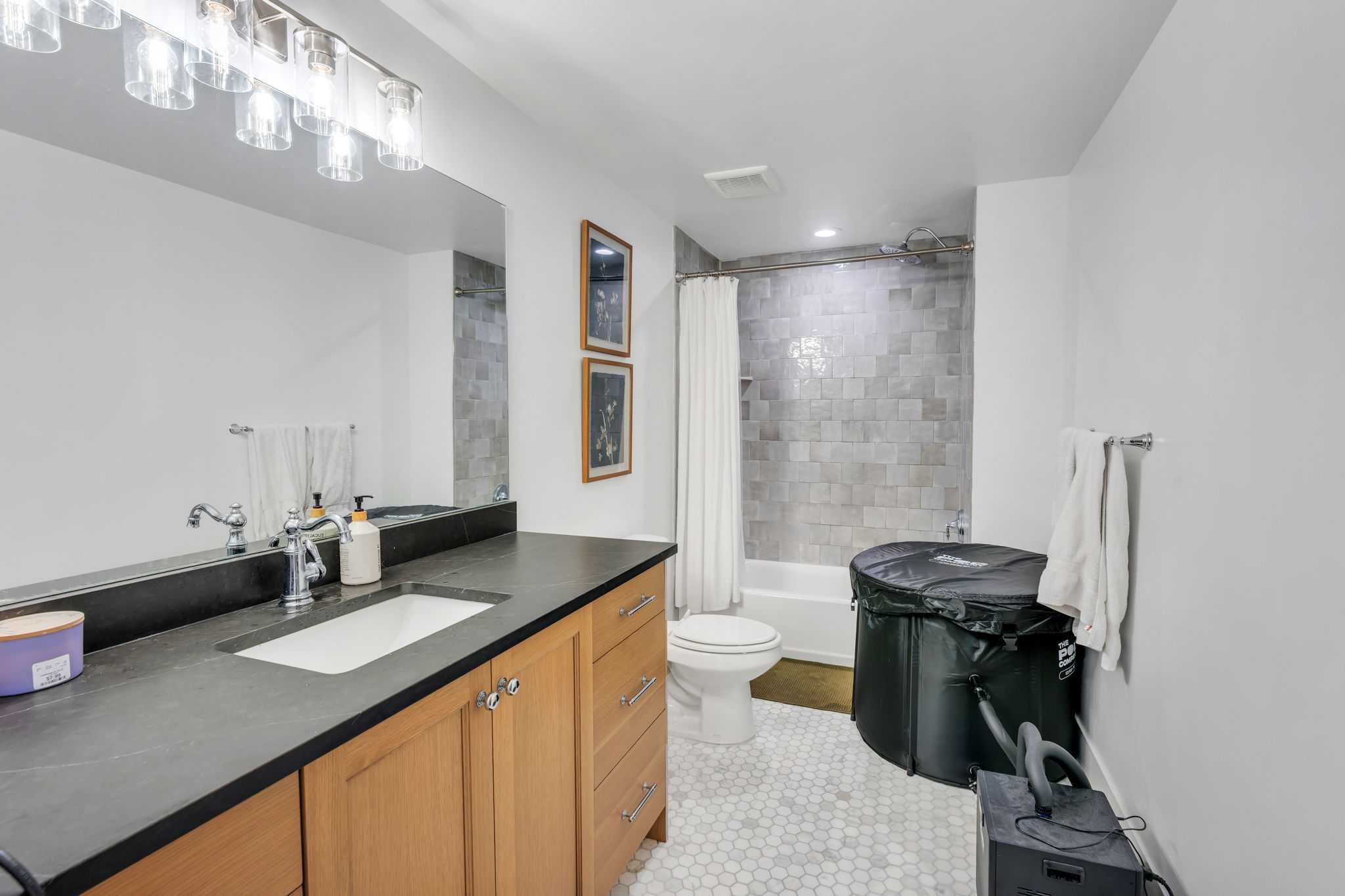 Bathroom featuring a wood vanity with a dark countertop, integrated sink, and brushed nickel fixtures