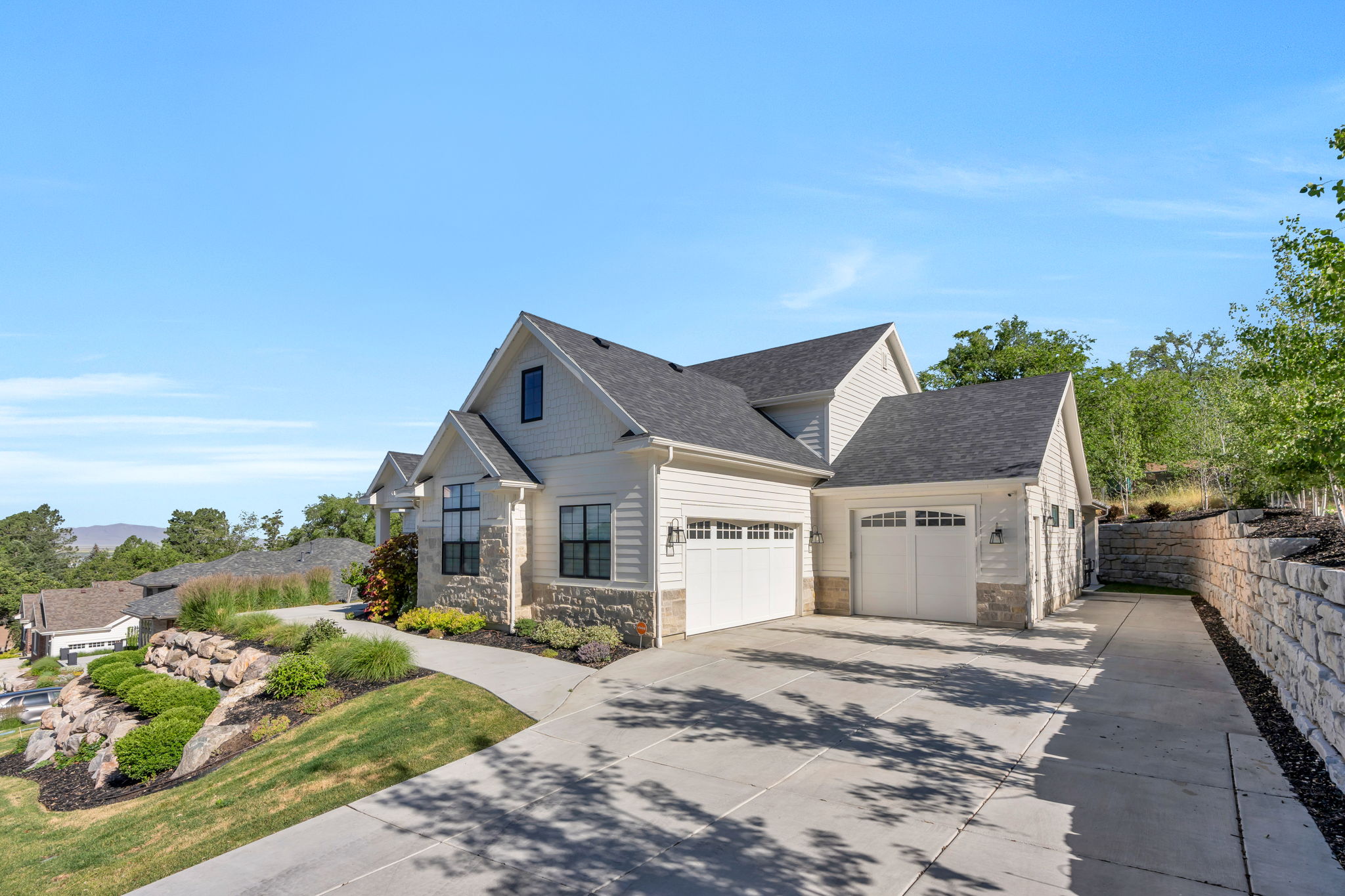 Contemporary residence featuring light siding and stone accents