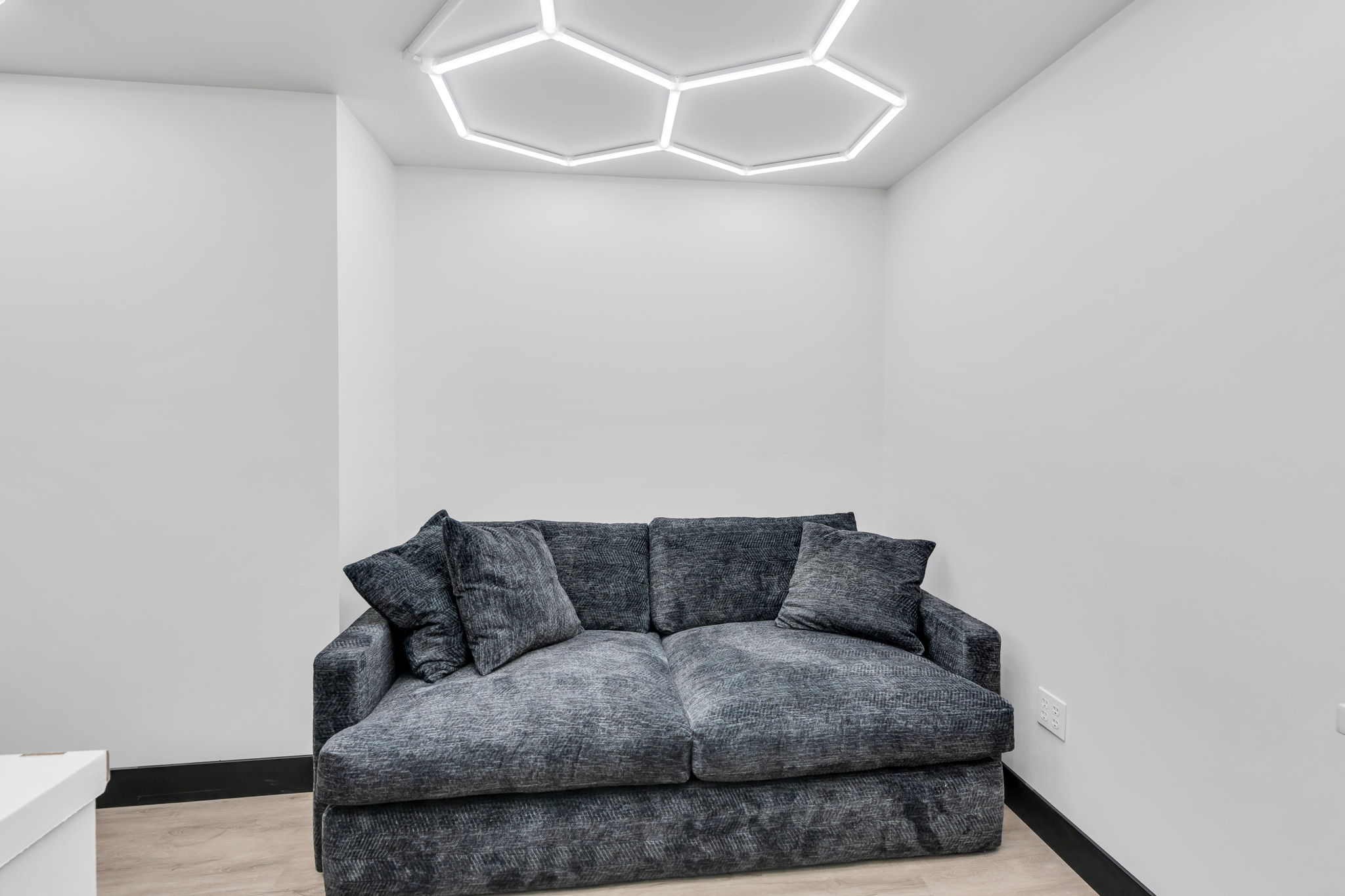 Recessed lighting, wood-finish flooring, and white walls create a bright and neutral interior