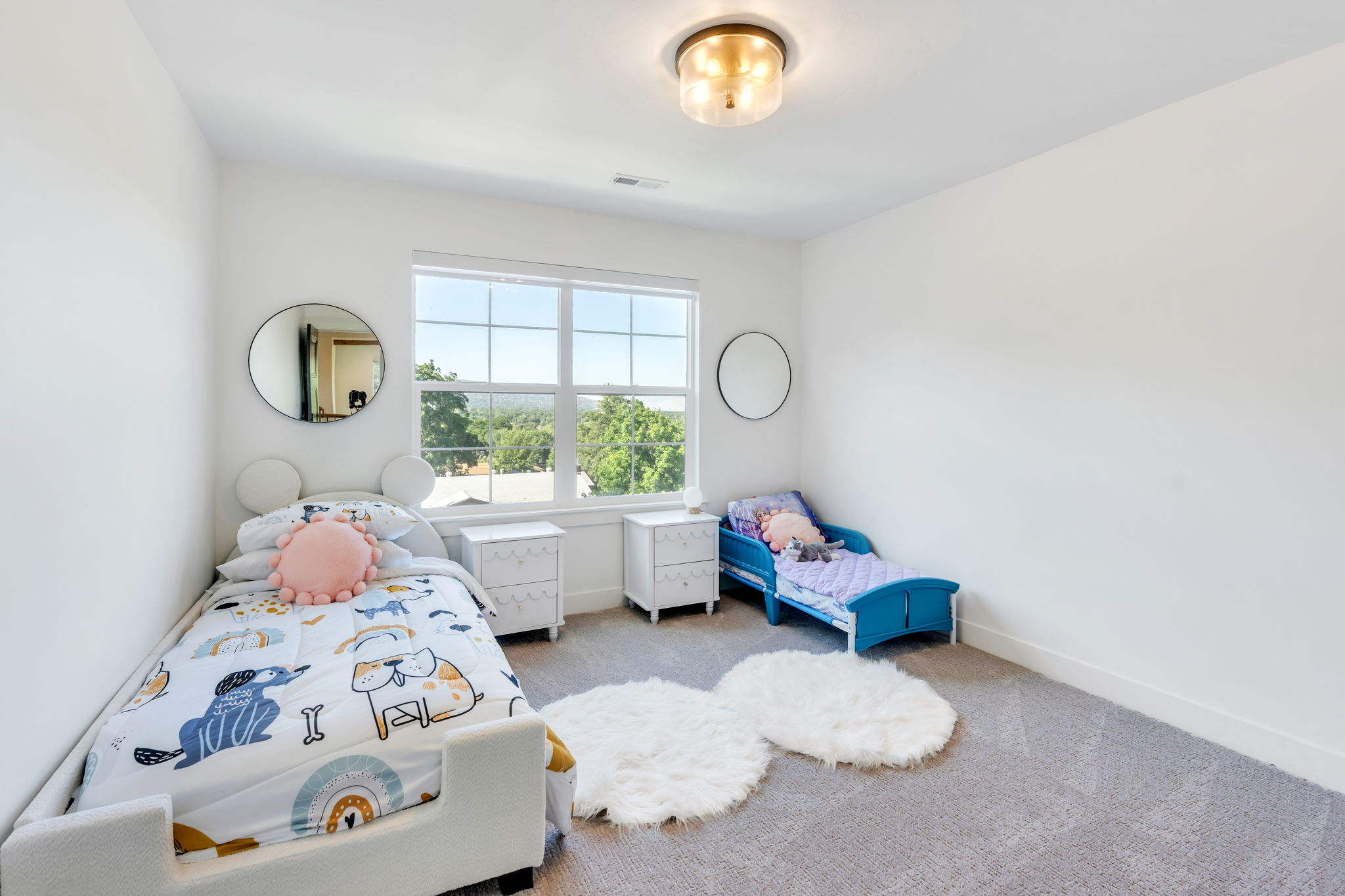 Light-filled room featuring a large window, neutral carpeting, white walls, and a contemporary ceiling light fixture