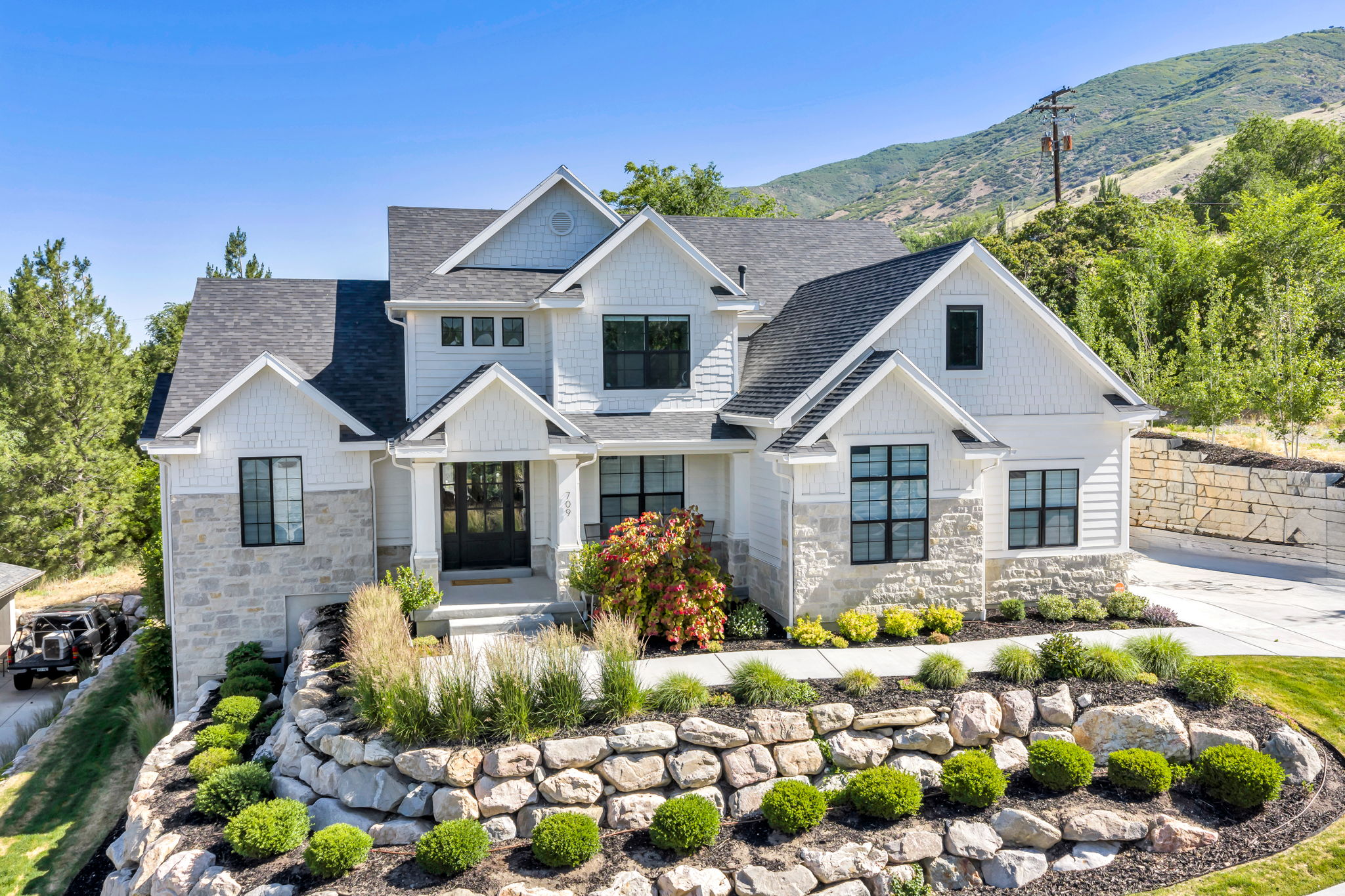 Modern farmhouse exterior featuring white siding and stone accents