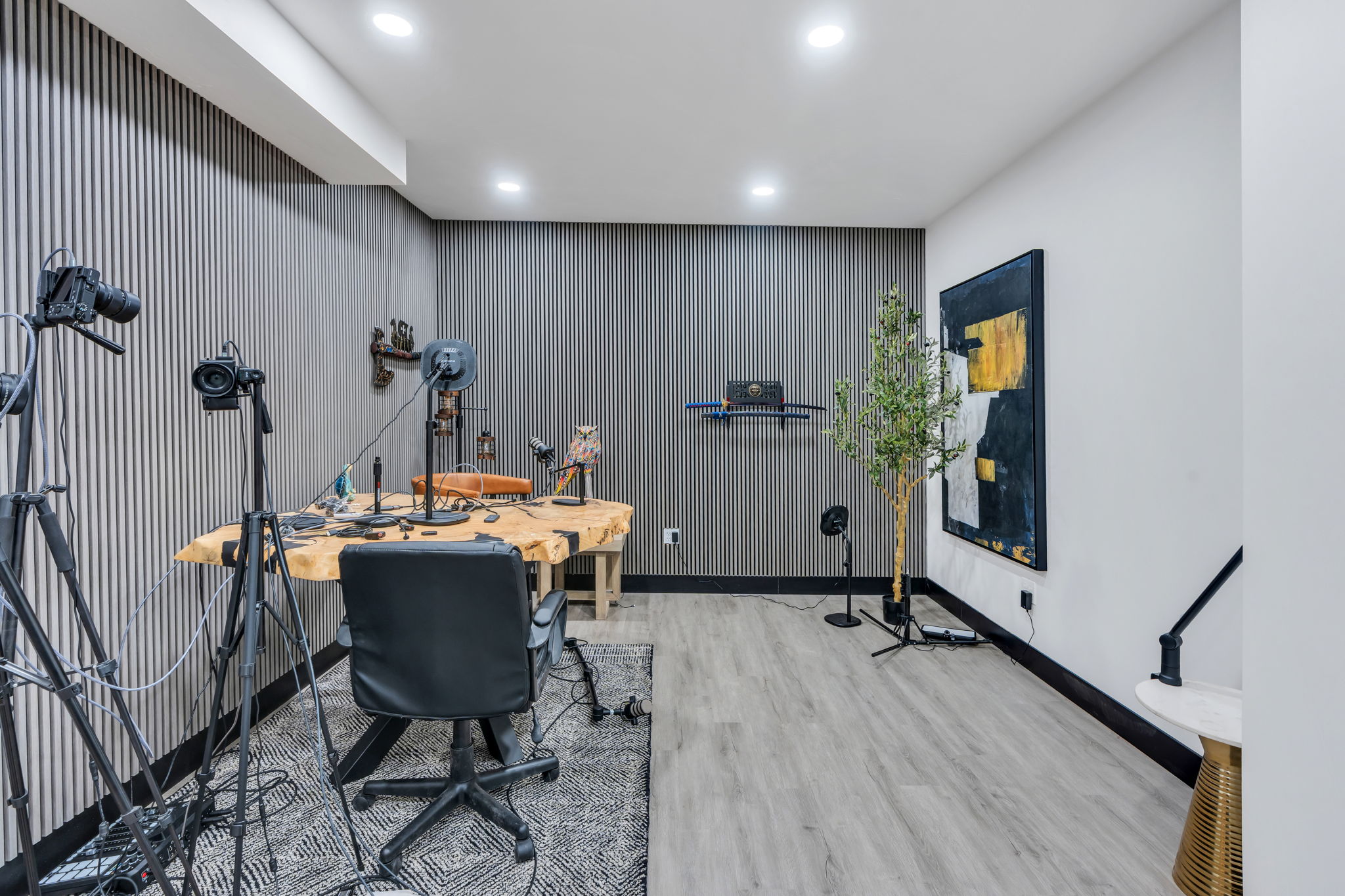 Dedicated room featuring vertical slat wall paneling, recessed lighting, and wood-finish flooring