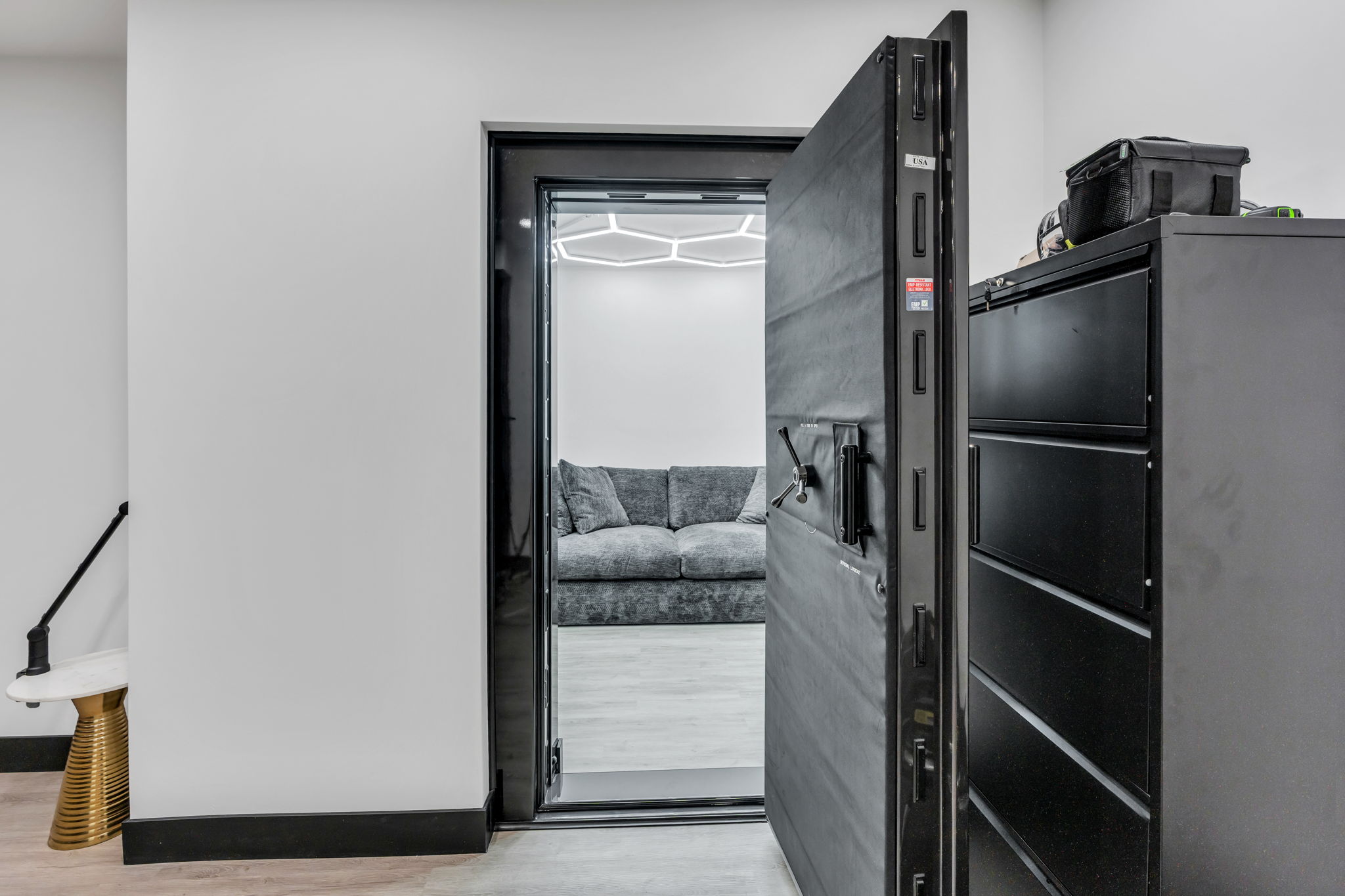 Heavy-duty security door opening to an interior space featuring wood-finish flooring