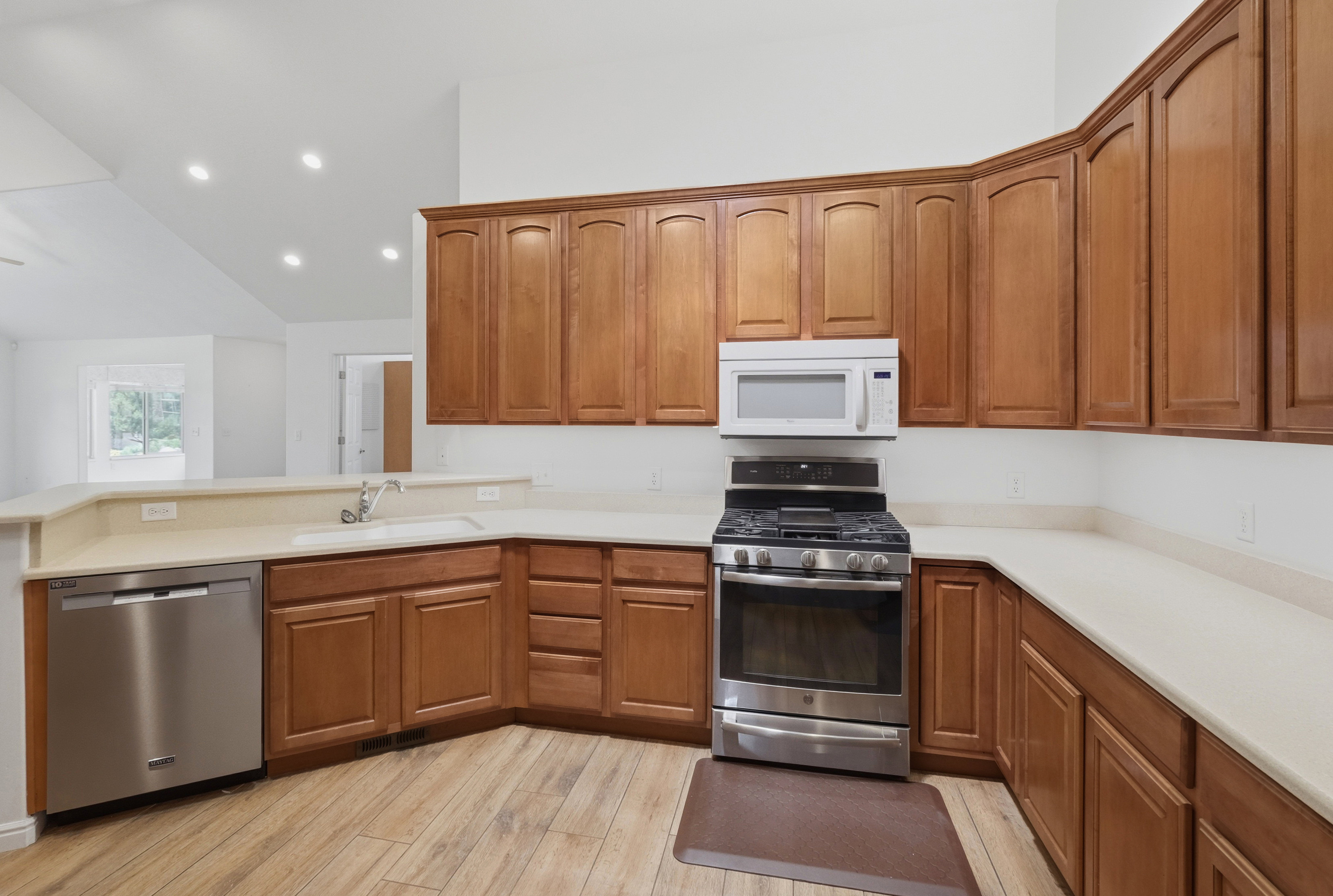 Kitchen featuring wood-finish flooring, light-toned countertops, and wood cabinetry