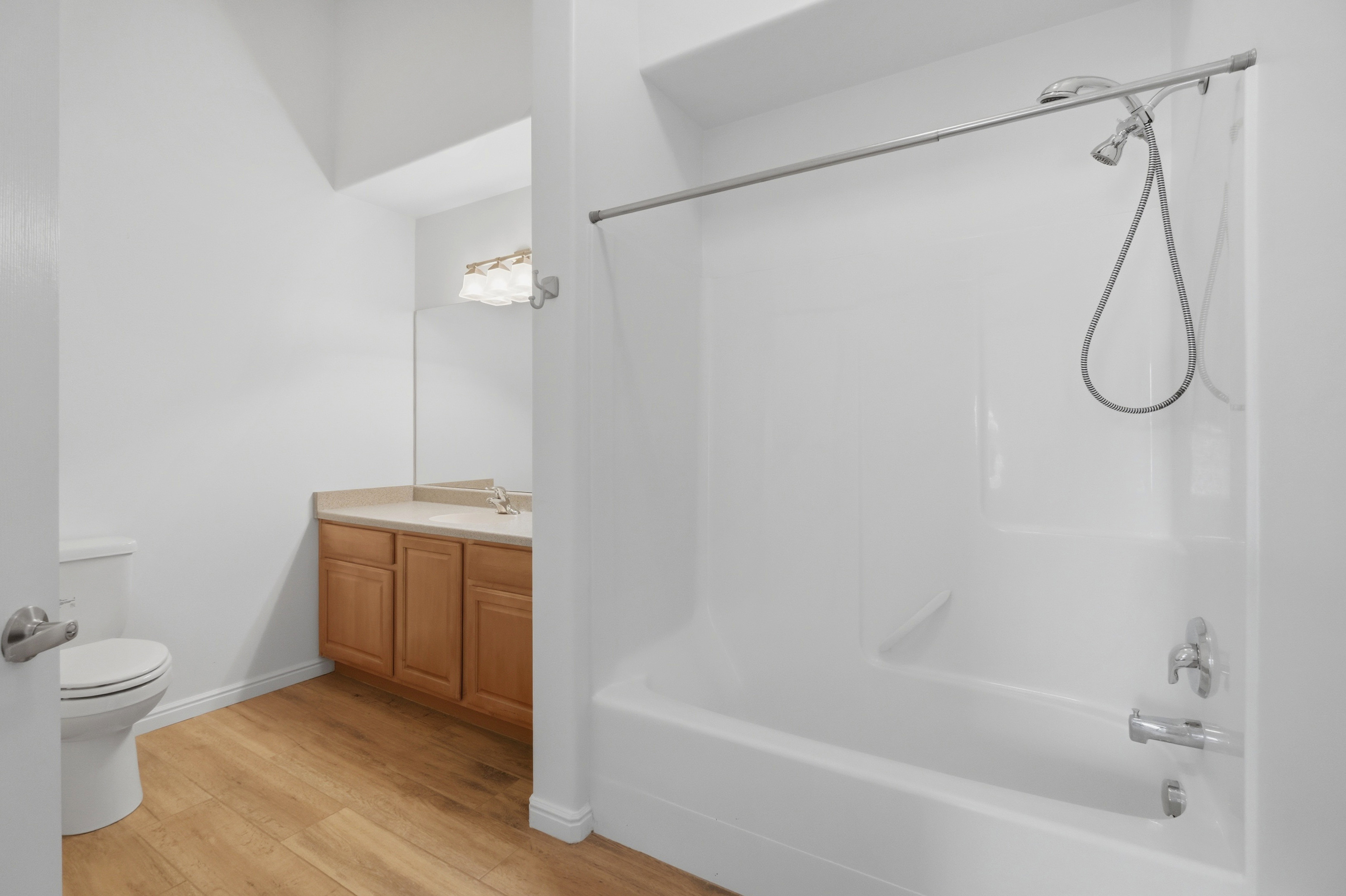 Bathroom featuring a combination bathtub and shower with a silver-finish shower head and a curved shower rod
