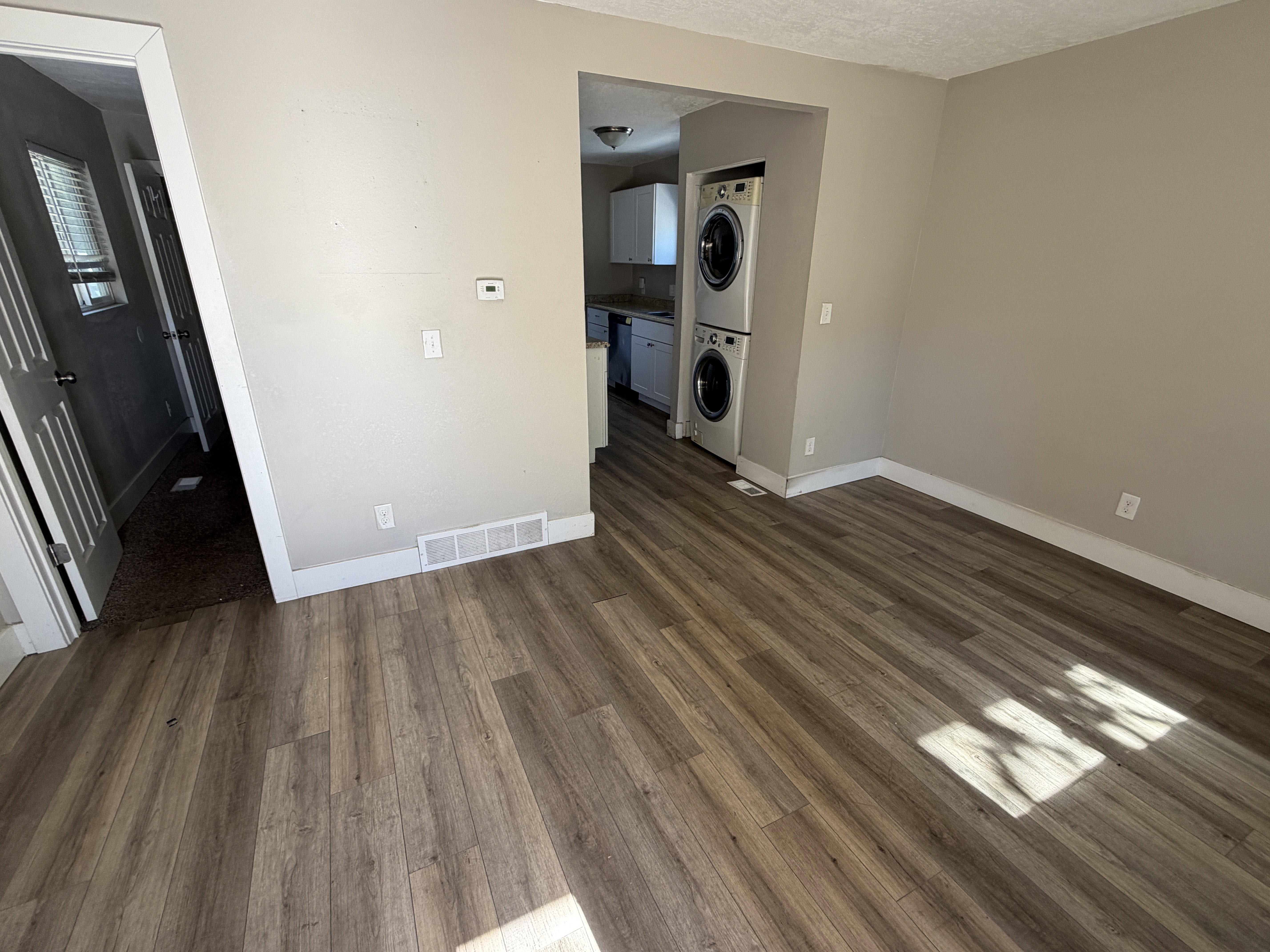 Open common area featuring wood-finish flooring, light neutral wall paint, and white trim