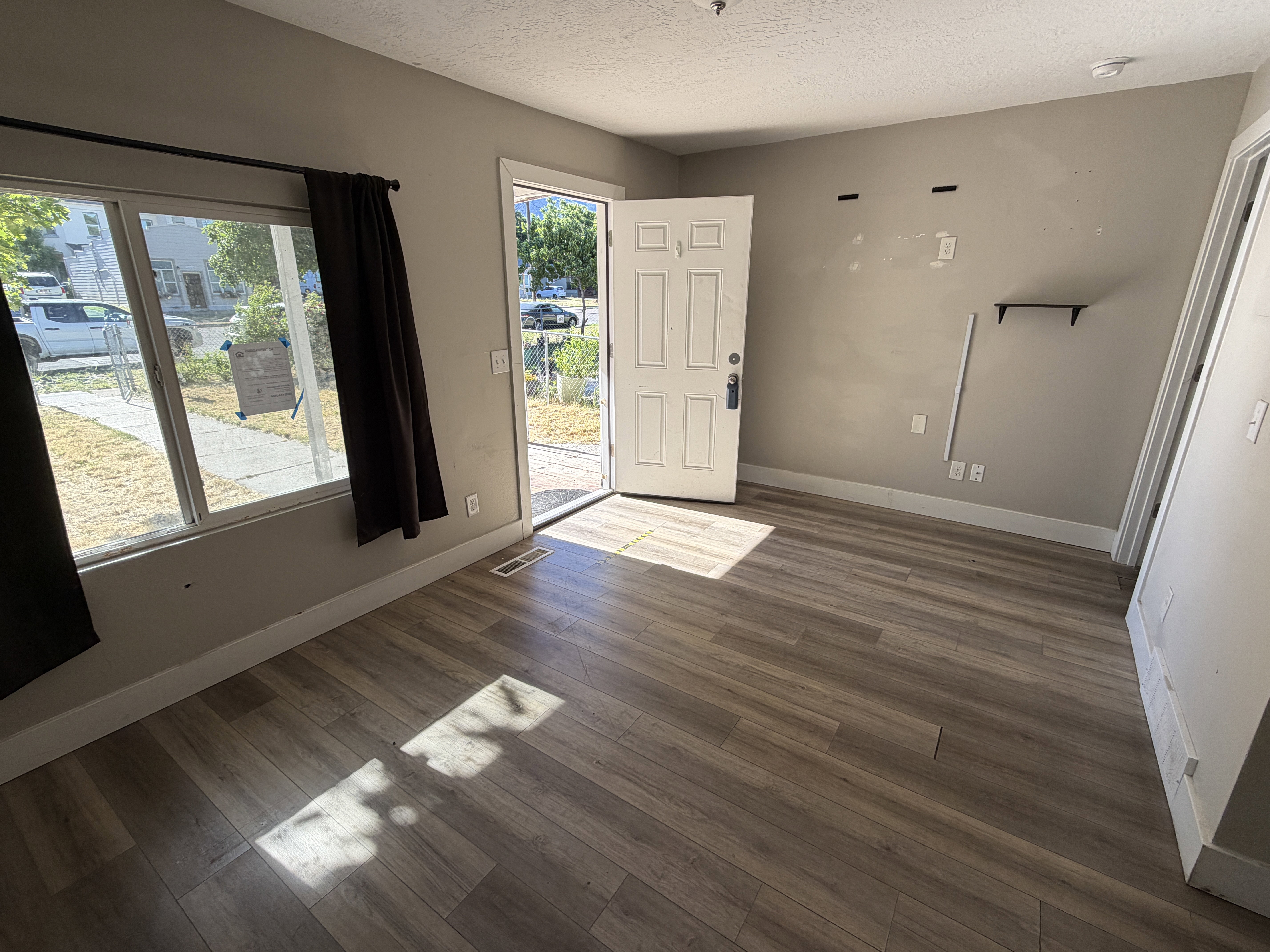 Bright entry area featuring wood-finish flooring, a white paneled entry door, and a large window