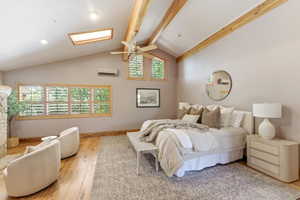 Vaulted ceiling with exposed wood beams and skylight