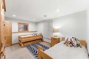 Carpeted room featuring recessed lighting and a window with wood plantation shutters