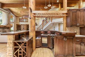 Full-service wet bar featuring wood-finish cabinetry, a built-in wine rack, stone accent pillar, beverage refrigerator, and integrated sink