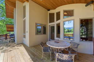 Spacious outdoor deck featuring wood flooring and a wood-paneled ceiling