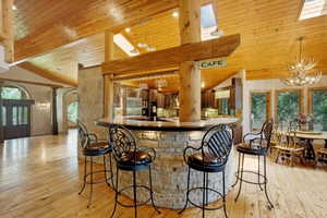 Stone-clad bar featuring a wood countertop and integrated lighting