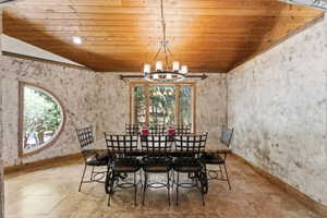Dining space featuring a wood-plank ceiling, textured walls, and a circular window