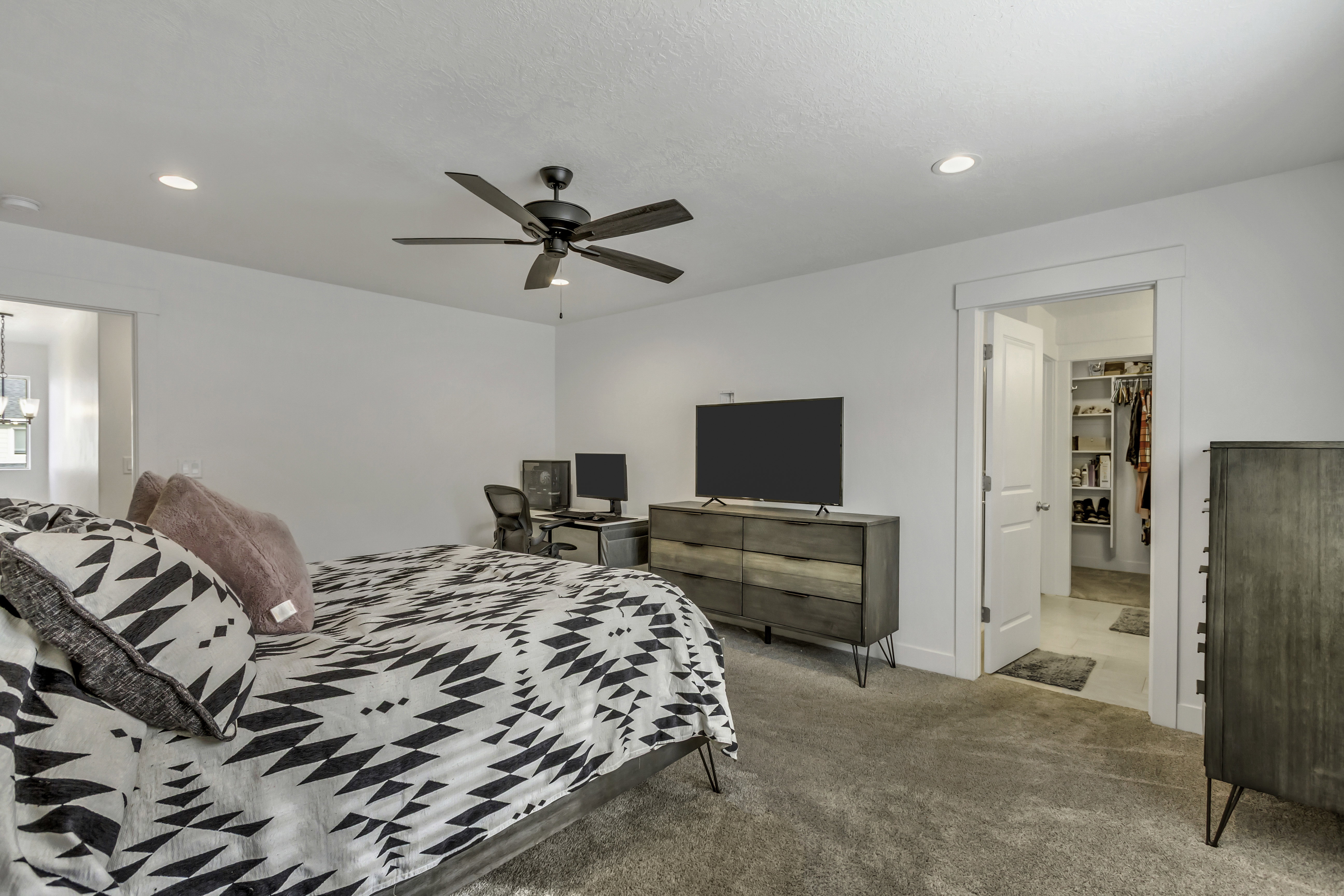 Spacious room featuring neutral carpeting, a ceiling fan with integrated lighting, and recessed ceiling lights