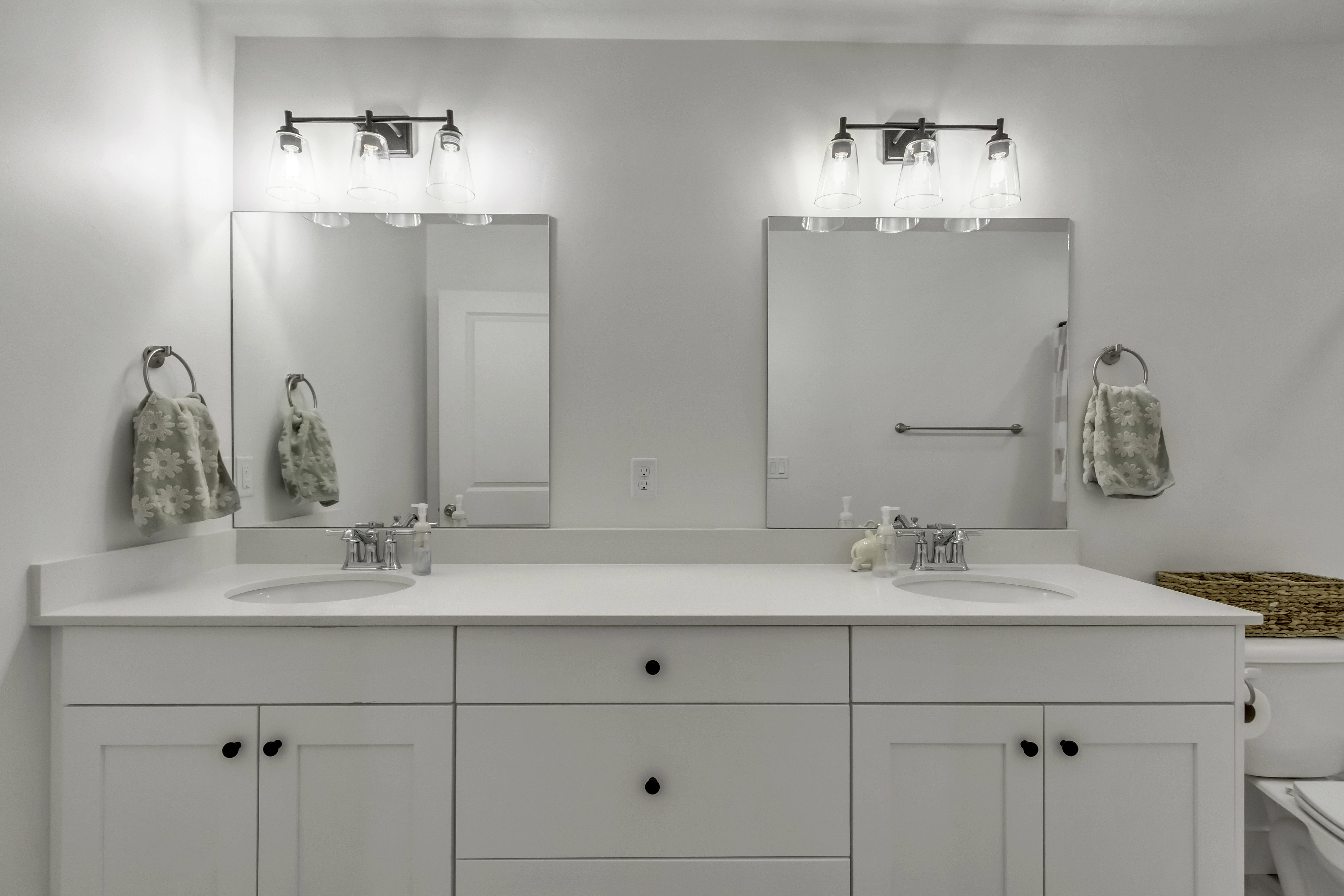 Dual vanity featuring white shaker-style cabinetry, undermount sinks, and polished chrome faucets