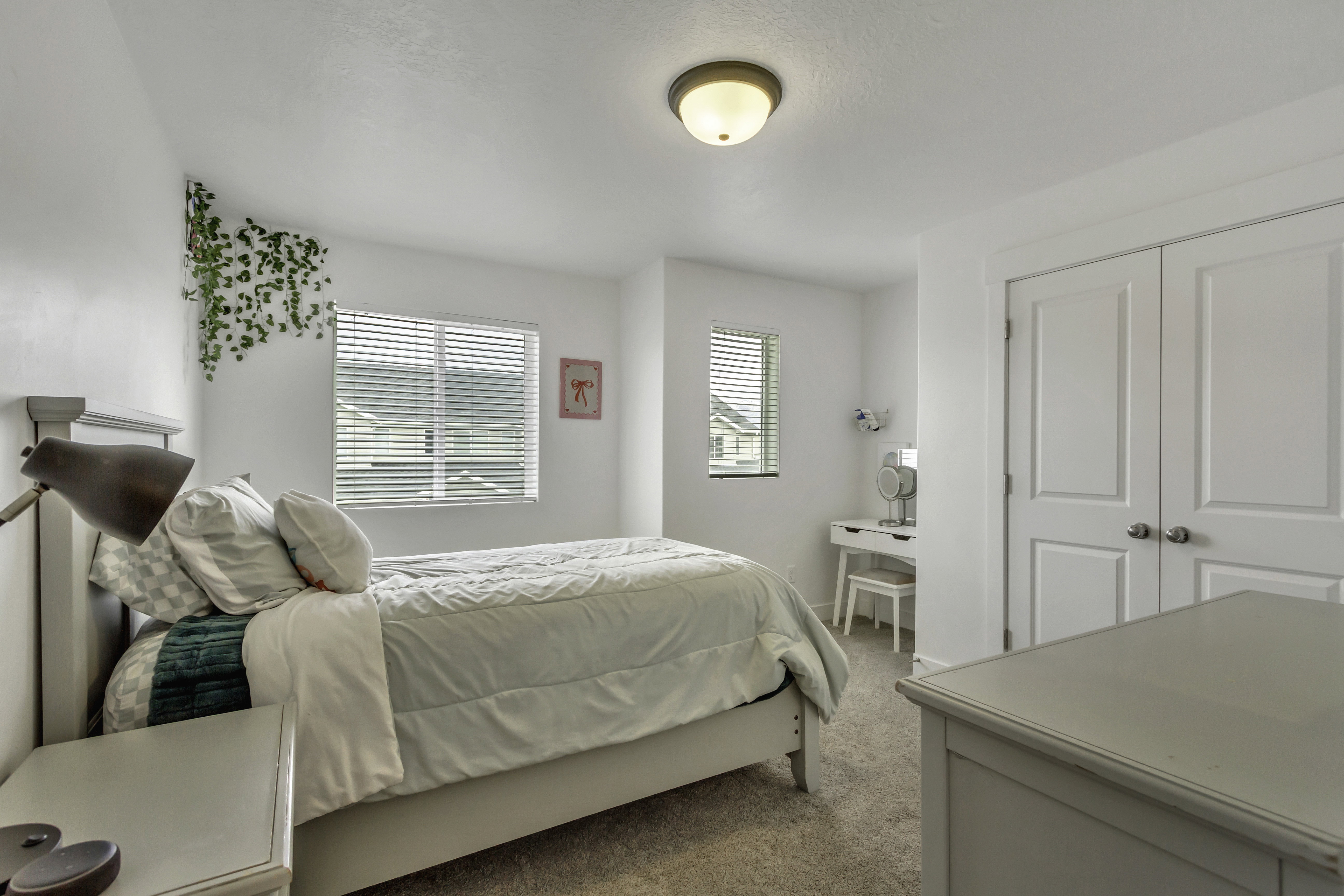 Bright bedroom featuring neutral-toned carpet and white walls
